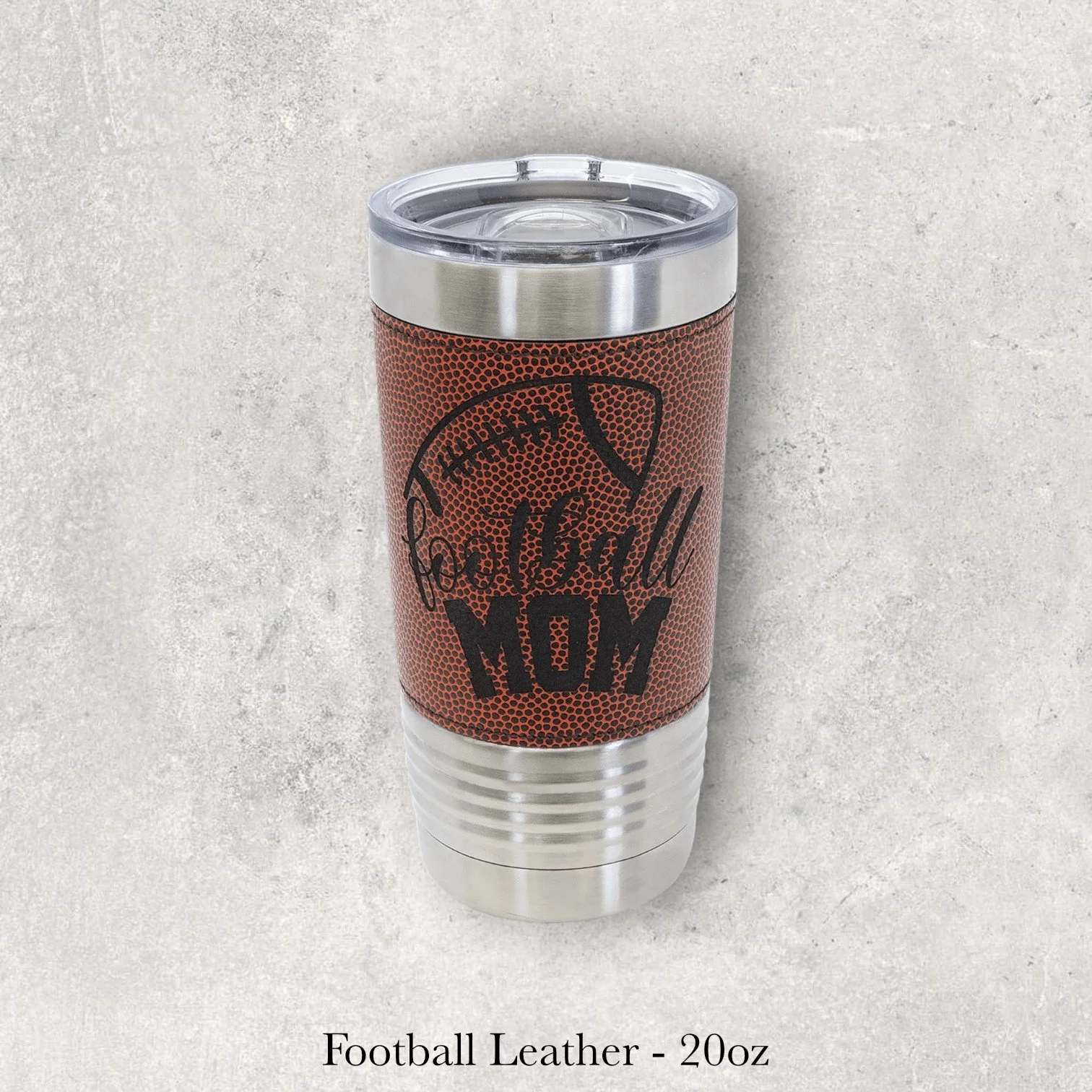 Silver base football leather 20oz tumbler with “Football Mom” text and football texture graphic, engraved by Lazeric