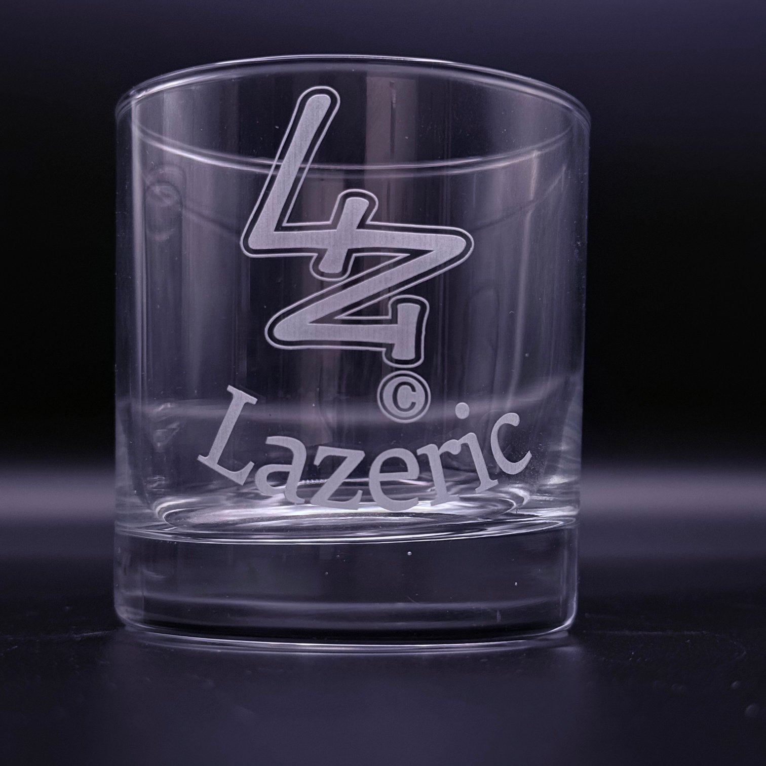Clear 10.5oz rocks glass with a custom laser-engraved Lazeric logo, shown as an etched design on the front of the glass