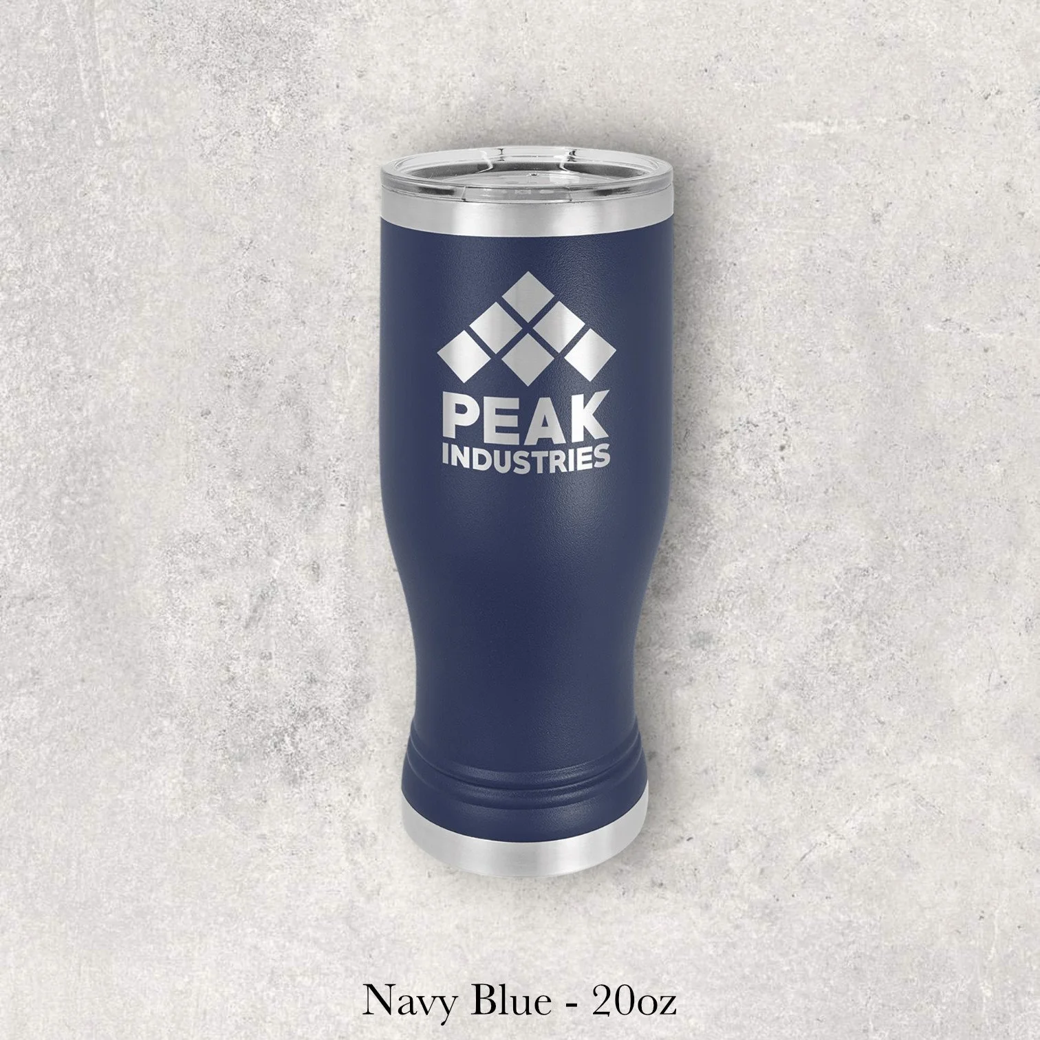 Navy blue 20oz pilsner-style tumbler engraved by Lazeric with the Peak Industries logo.