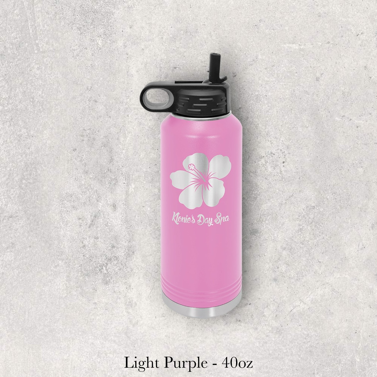 Light purple 40oz metal water bottle engraved by Lazeric with a floral logo and boutique-style text.