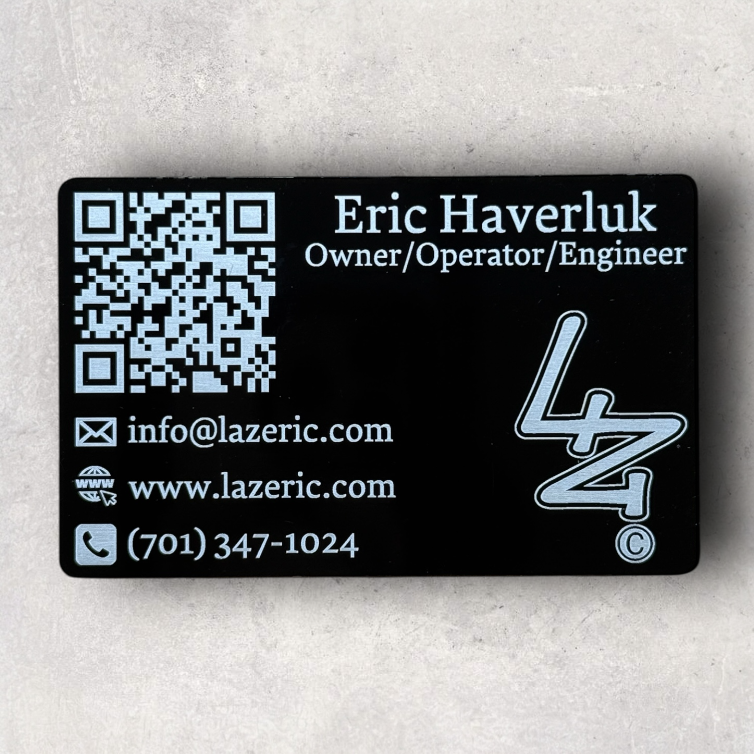 Laser engraved black metal business card for Eric Haverluk of Lazeric, featuring contact info, logo, and QR code - Lazeric