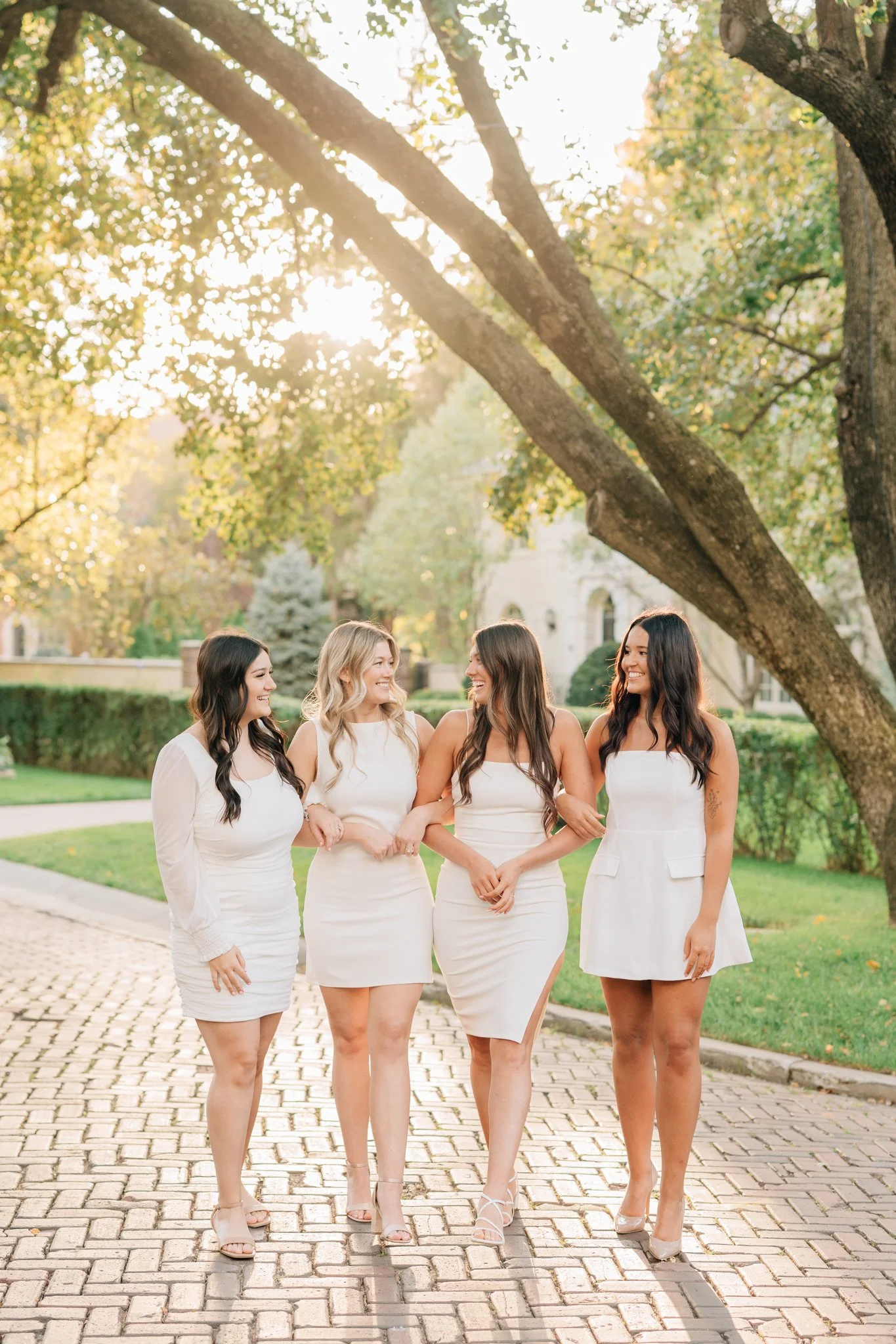 4 nursing students in white dresses celebrate graduation with photos in Omaha.