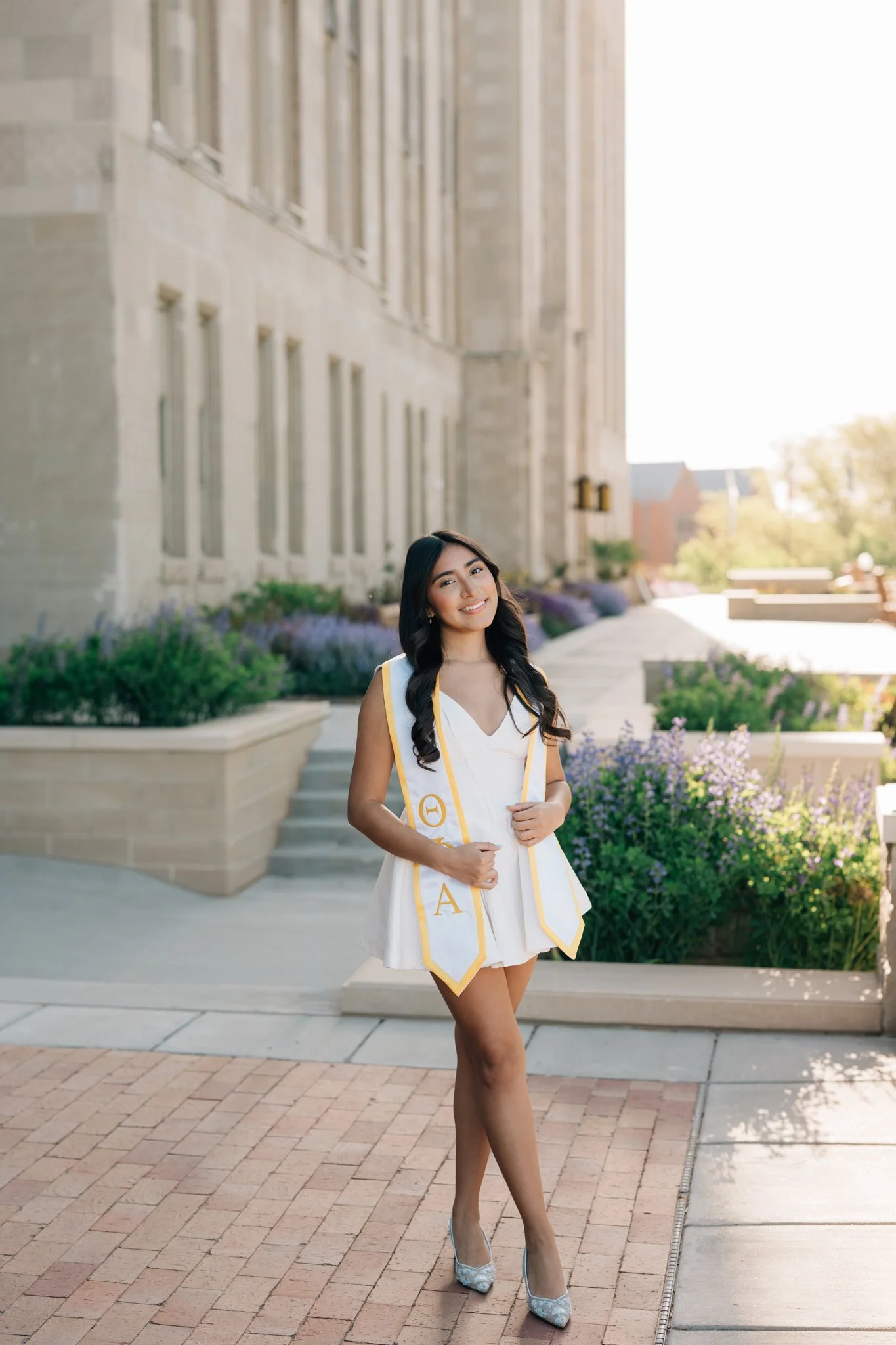 Creighton graduate wears her stole outside admin building during her college graduation photos in Omaha .