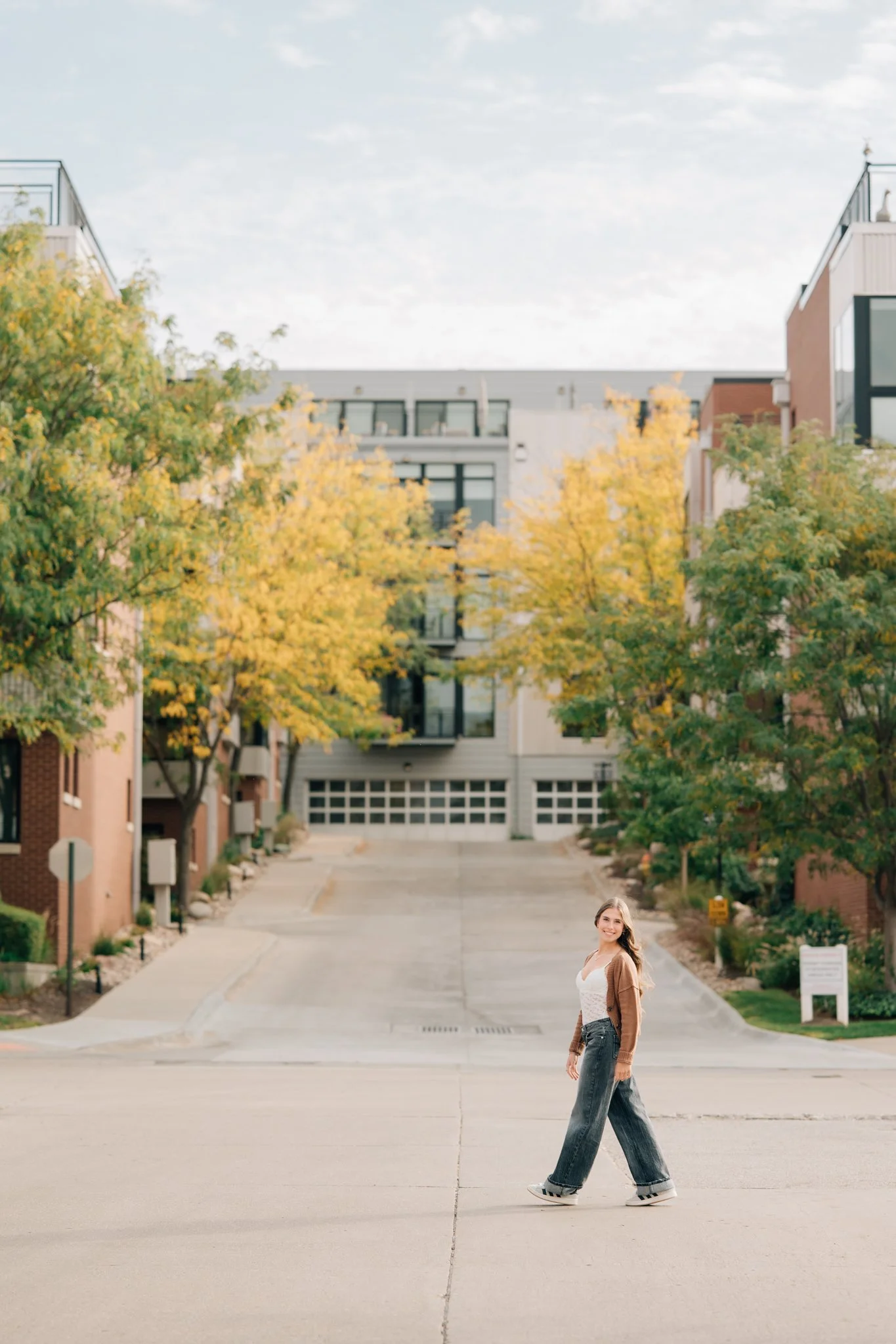 Girl walks across the street in downtown Omaha for her senior pictures.