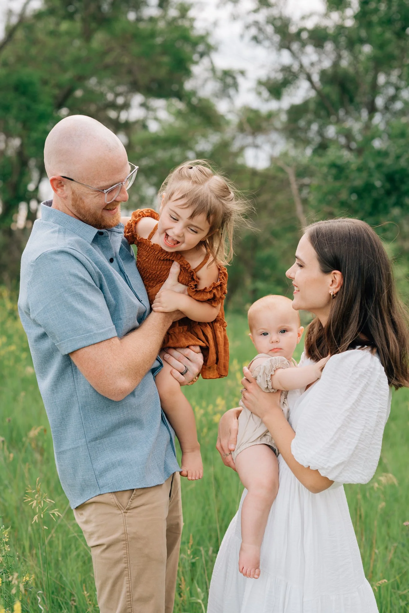 Family makes daughters laugh during family pictures in Iowa. 