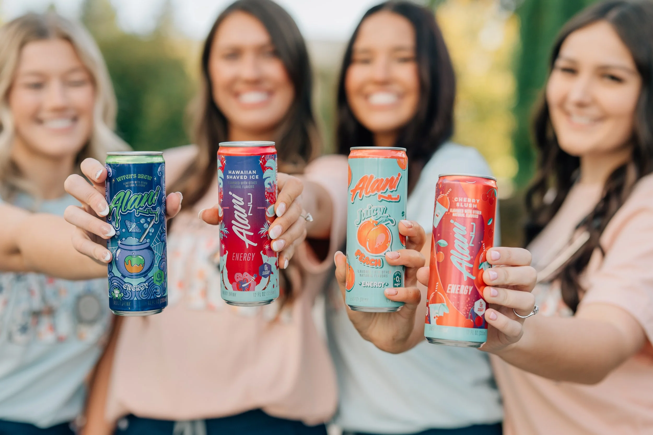 4 graduates cheers Alani drinks to celebrate their graduation and a nod to all of the caffeine it took.