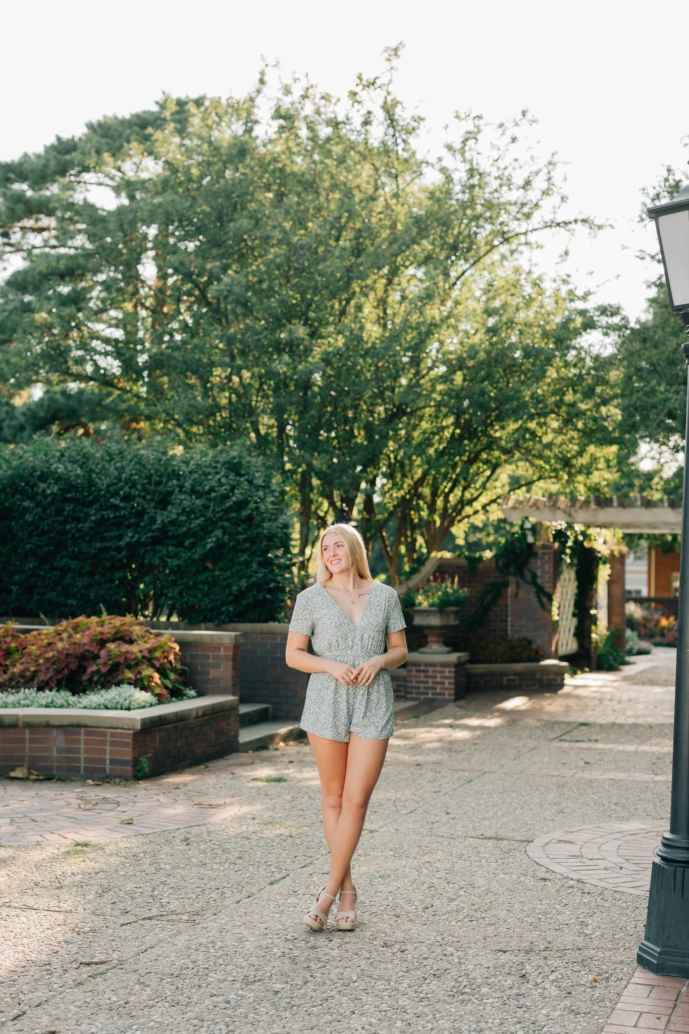 Girl poses in garden for her Omaha senior pictures.