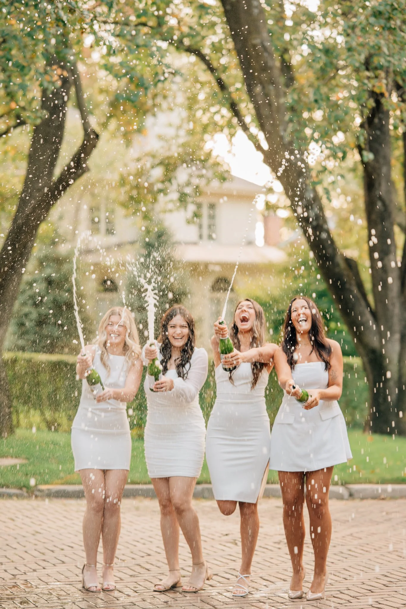 4 nursing students pop champagne to celebrate graduation.