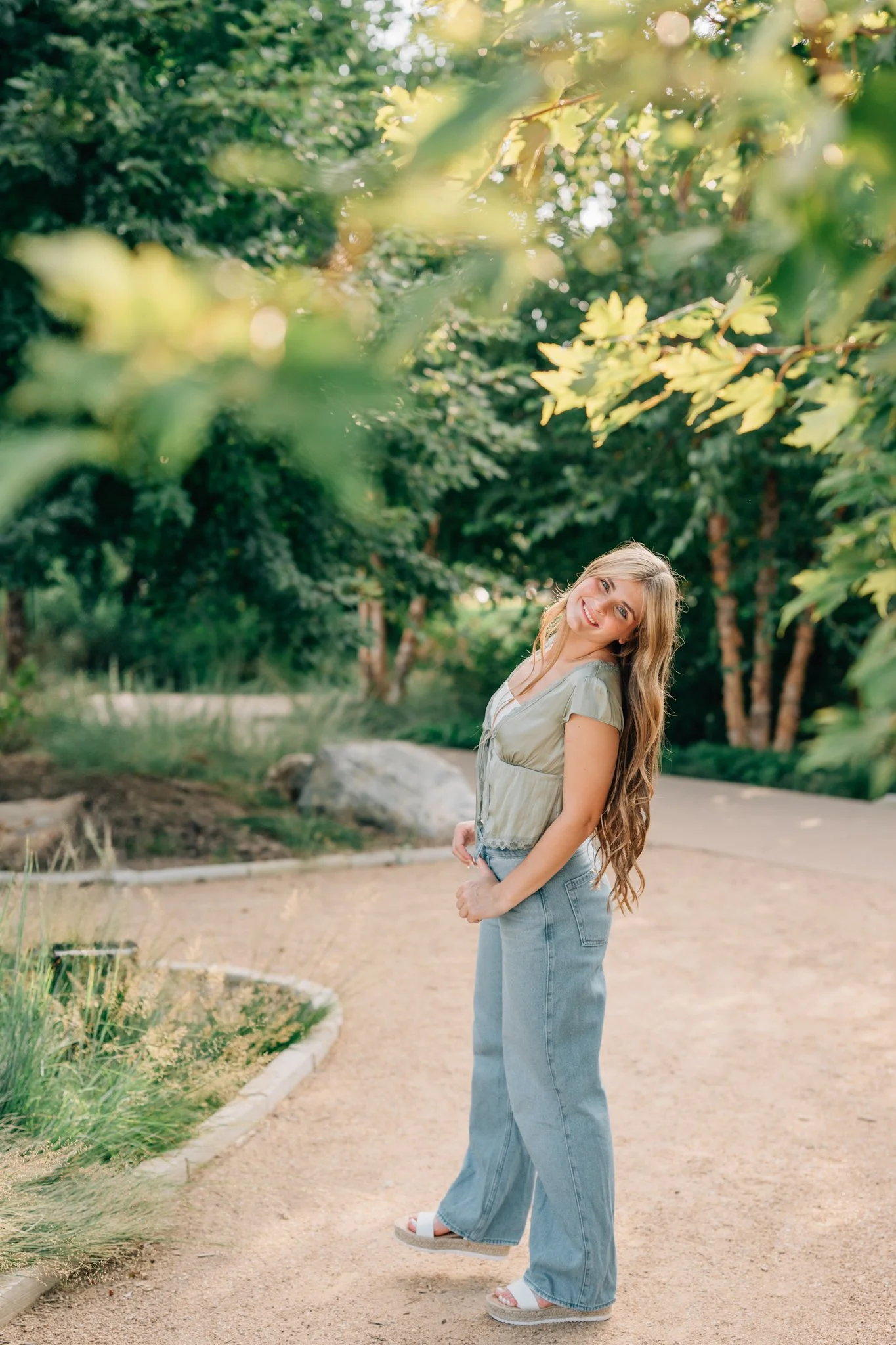 Girl smiles at the camera as she walks away during her senior pictures in downtown Omaha, NE.