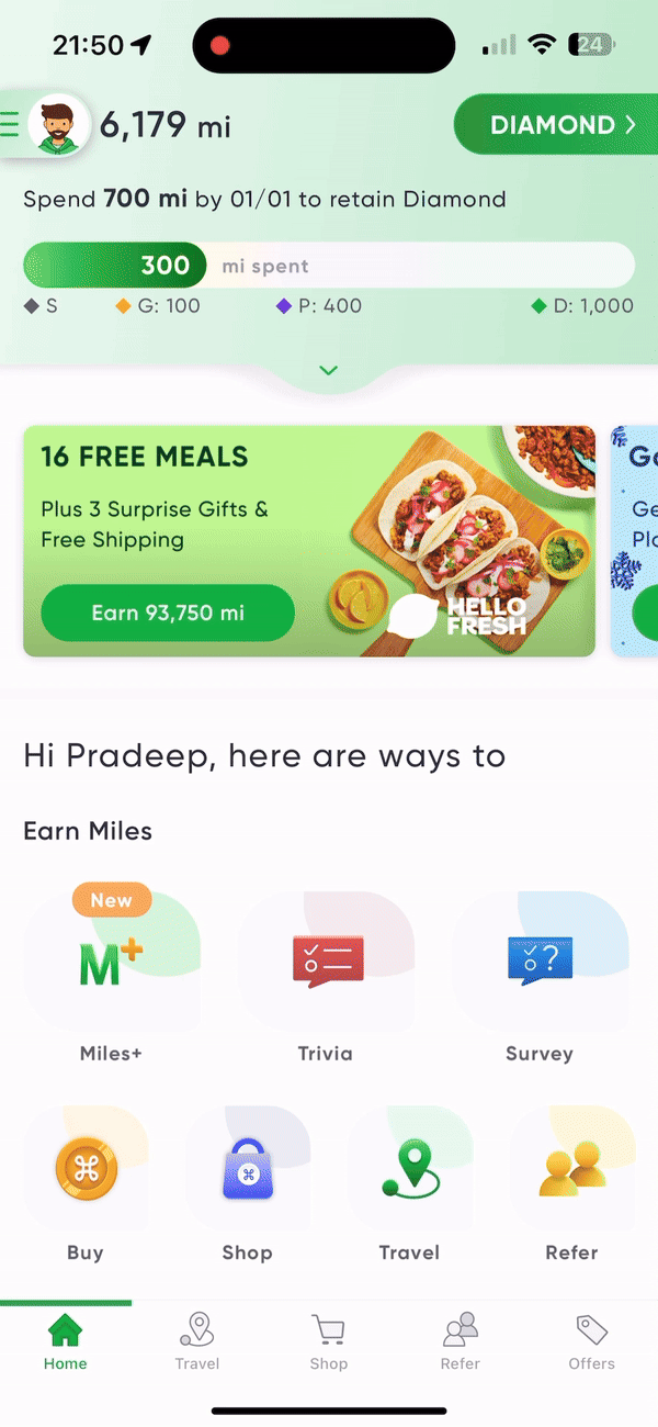 Mobile app interface showing travel rewards, miles tracker, and ways to earn points, including miles, trivia, and survey options. Display highlights 16 free meals offer with a food image. Bottom navigation includes Home, Travel, Shop, Refer, Offers tabs. Green and white color scheme.