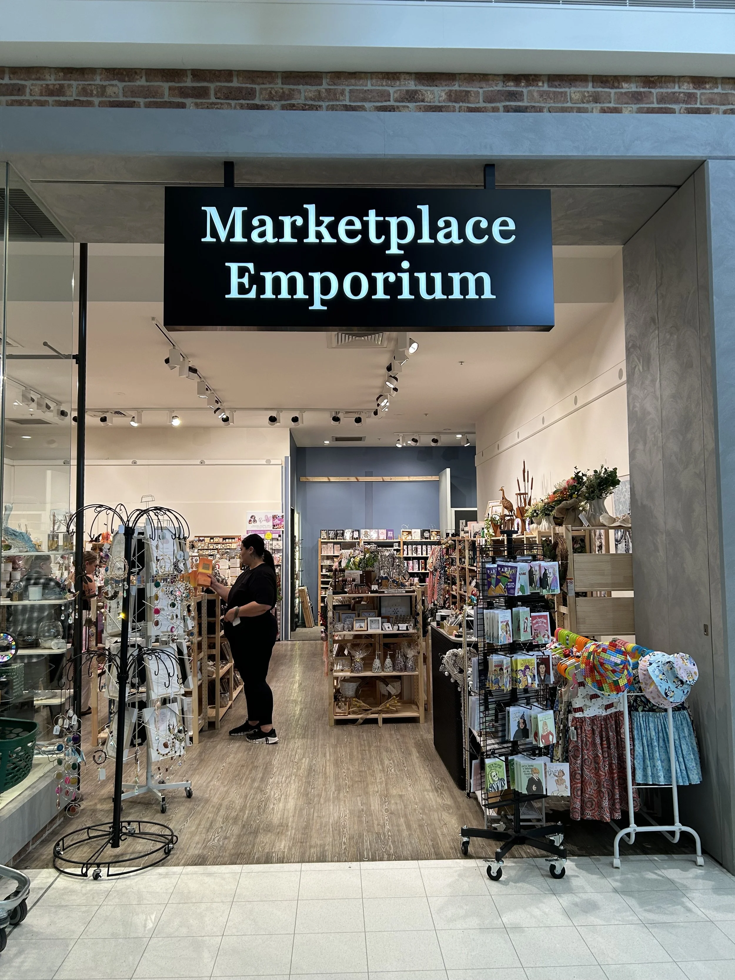 Entrance to a store called Marketplace Emporium, selling jewellery, books, clothing, and decorative items inside Marketplace, Lilydale shopping mall.