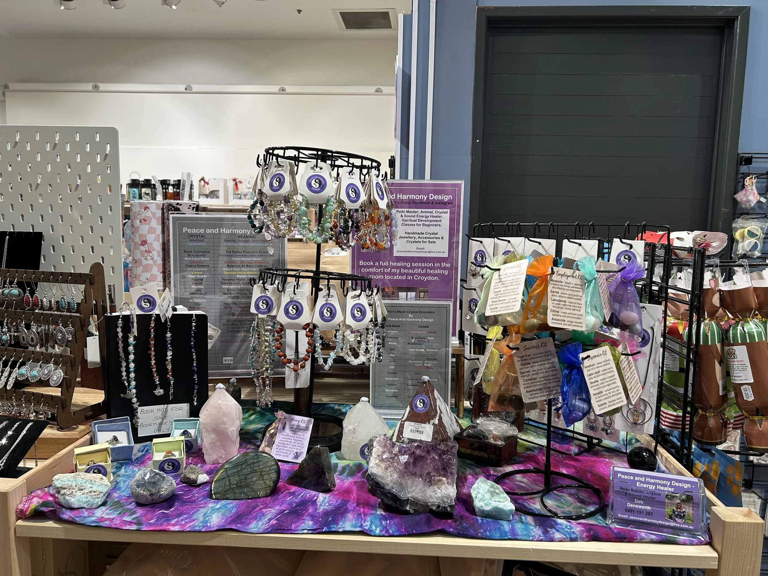 Peace and Harmony Designs' display of jewellery and crystals at Marketplace Emporium, Lilydale , with necklaces, bracelets, and various gemstone pieces promoting healing and energy work.