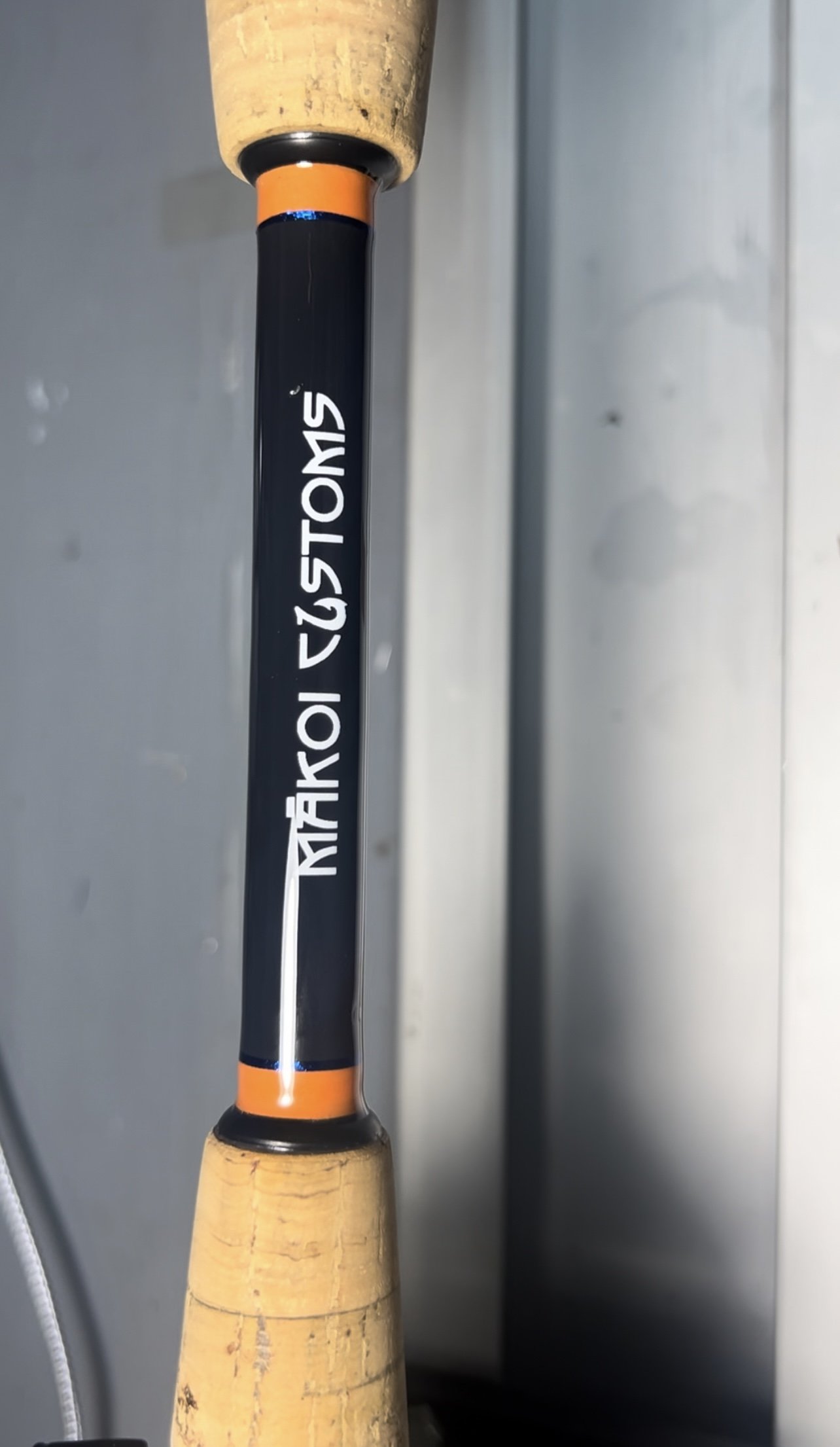 close-up of a fishing rod handle with 'Mako Customs' logo