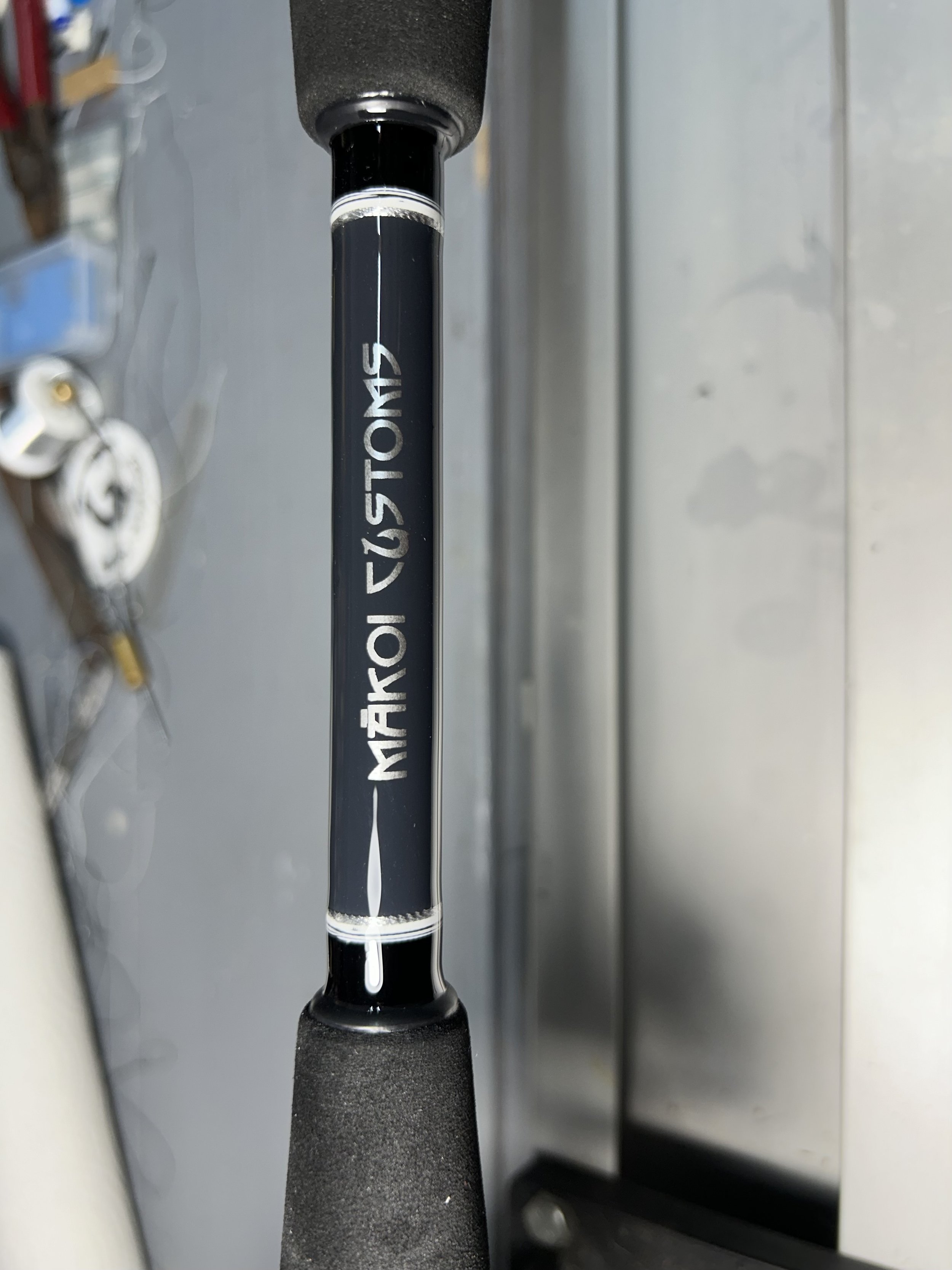 Close-up of a fishing rod with 'Mako Customs' label on blank section.