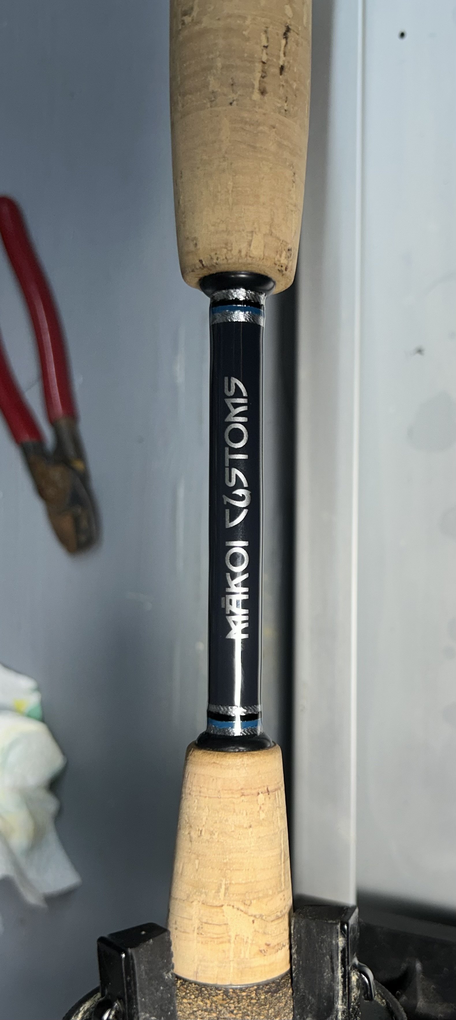 Custom fishing rod handle with label "Makoi Customs"