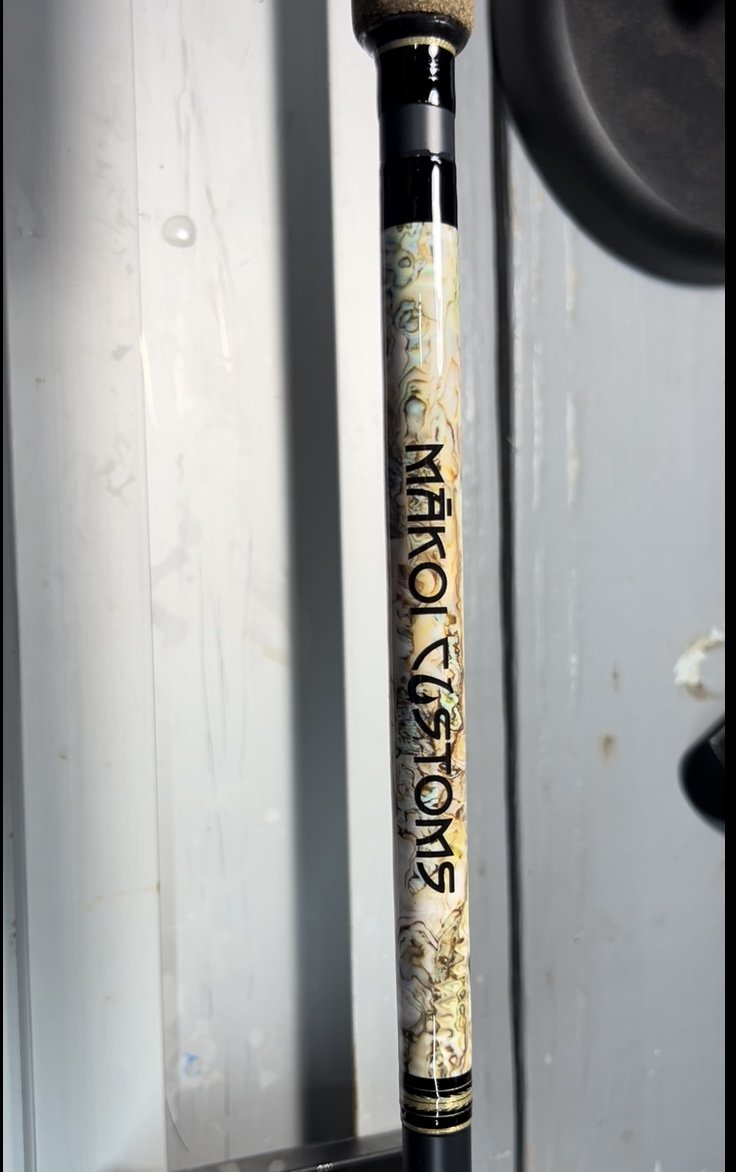 Fishing rod with "Mako Customs" branding and decorative handle.