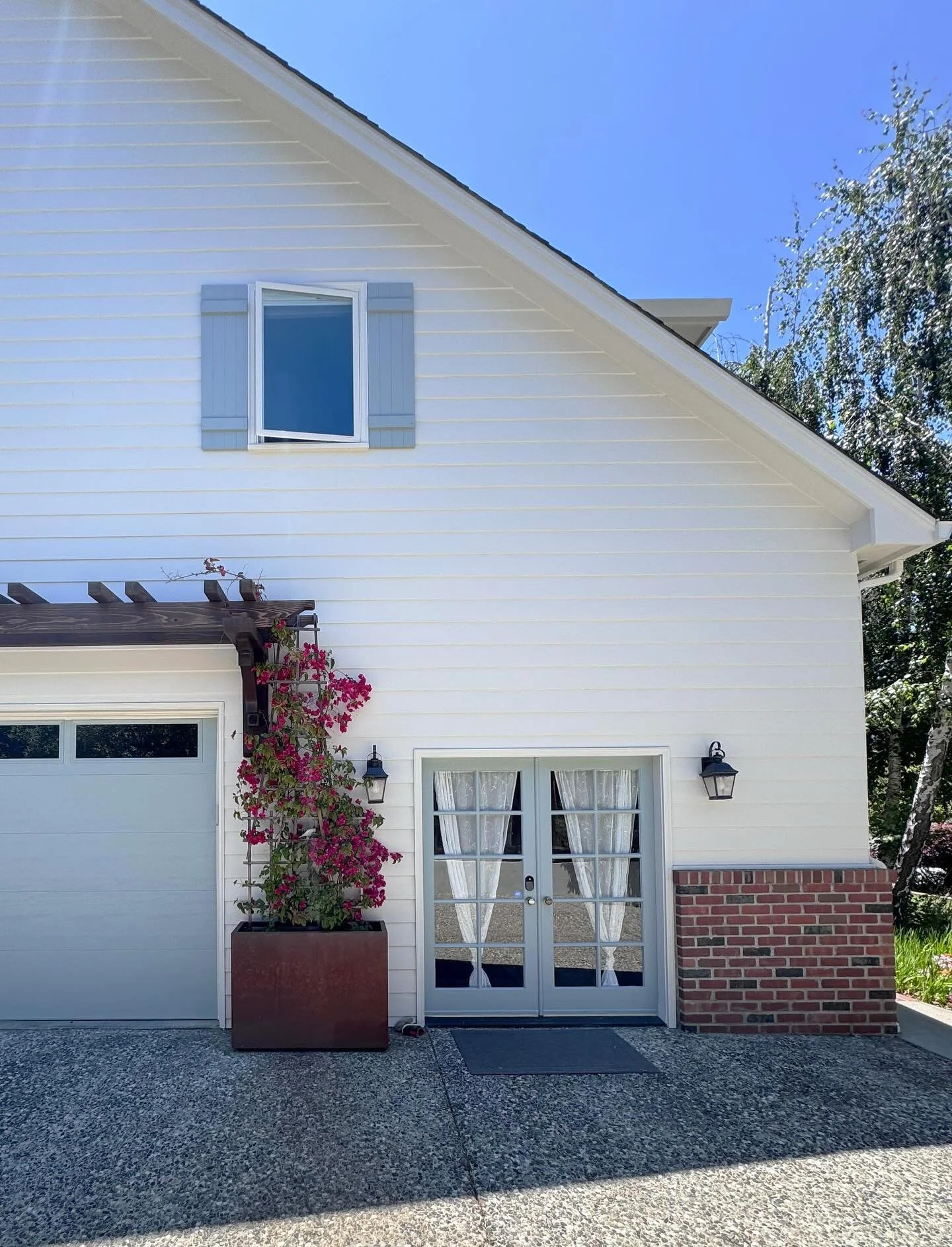 Creamy white and soft blue are the perfect color backdrop for Bougainvillea and warm elements (wood, brick and Corten steel) to create a sense of balance and contrast.