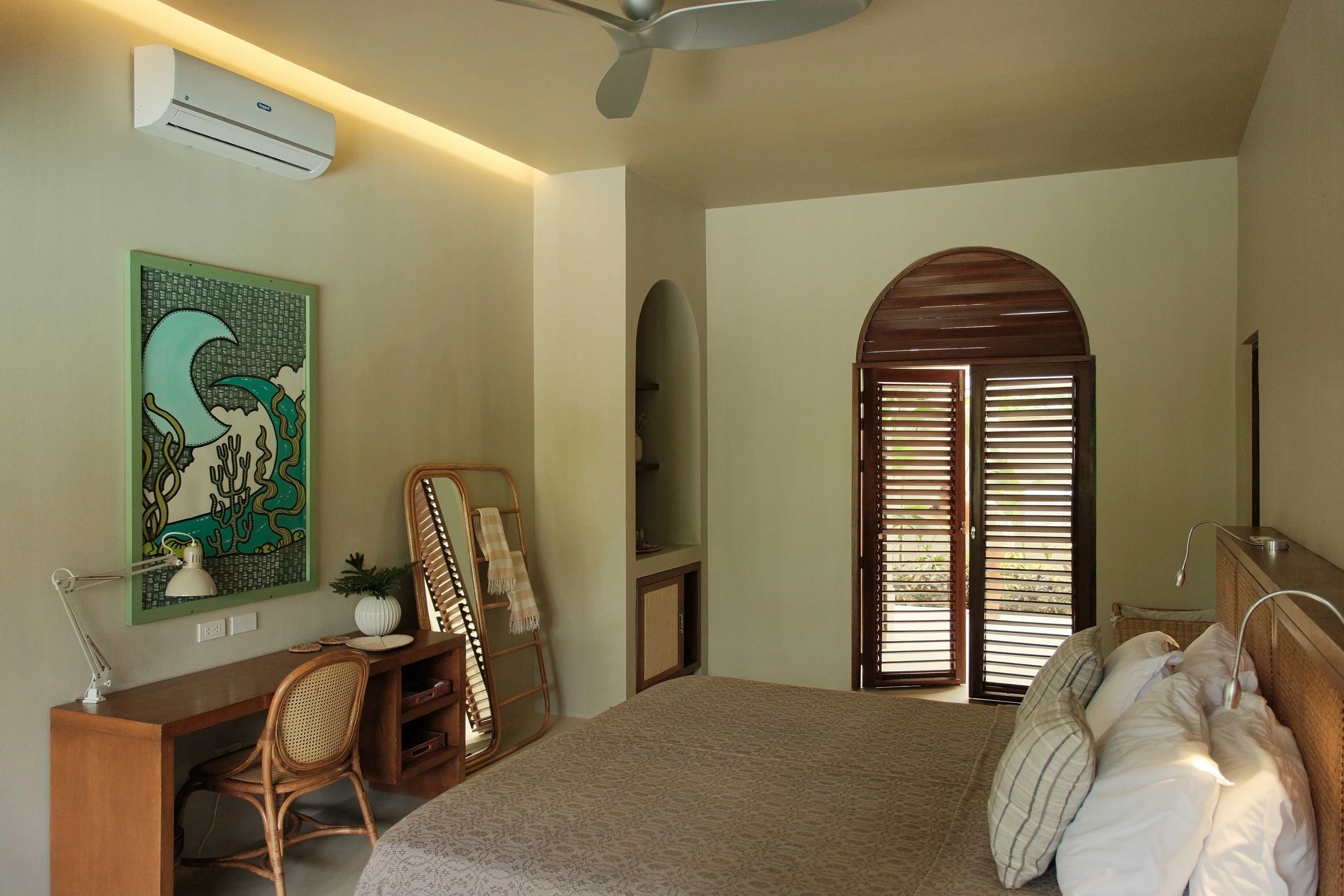 A spacious Poolside Suite with warm lighting, natural textures and direct access to the relaxed villa atmosphere around the large swimming pool.