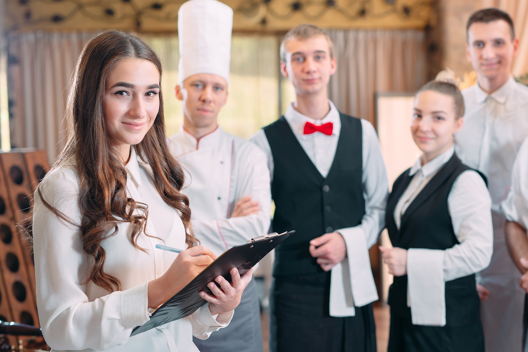 Server, manger, chef standing in a meeting smiling