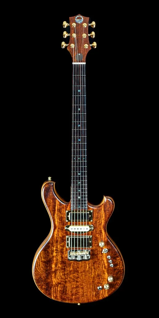A wooden electric guitar with gold and chrome hardware, set against a black background.