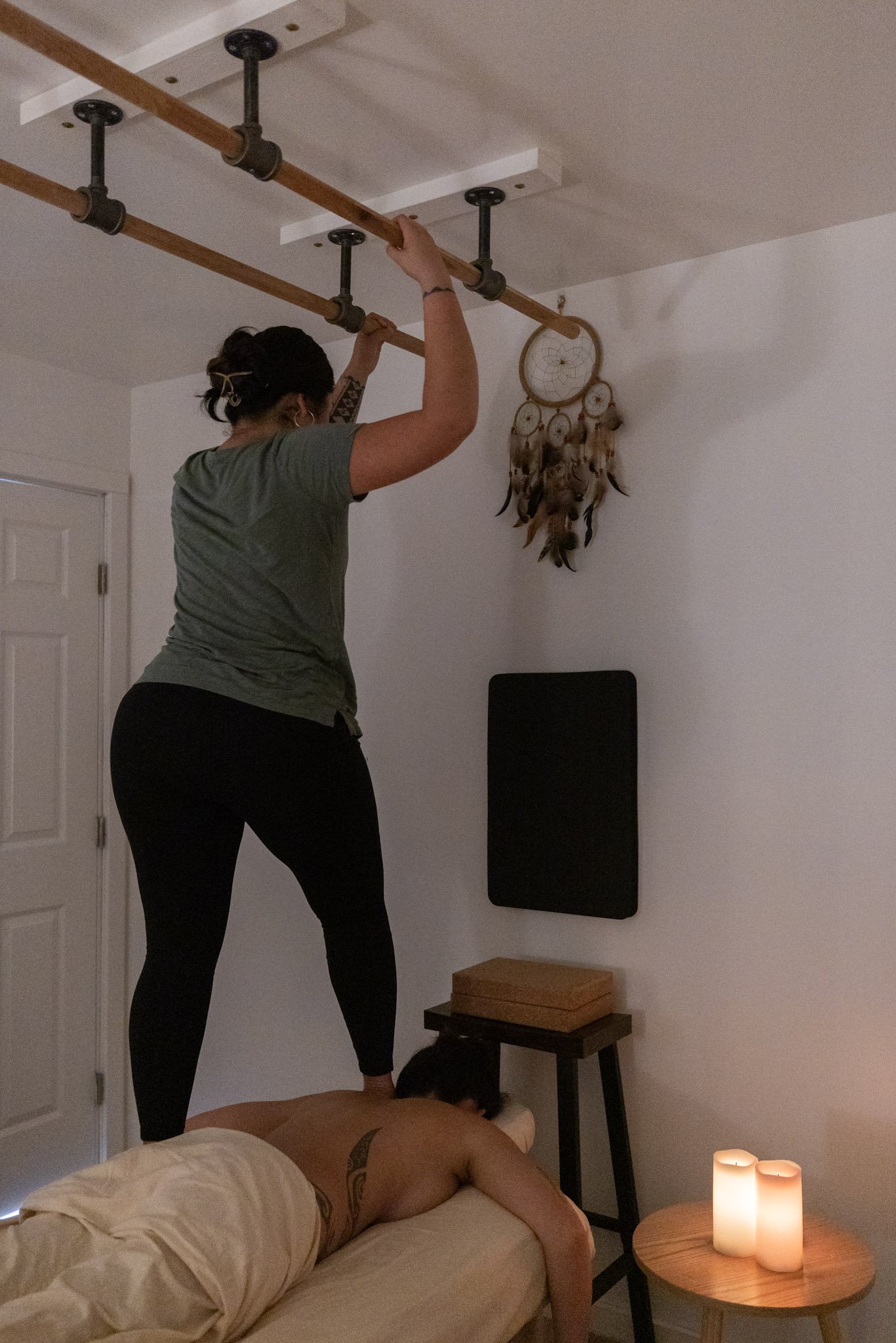 a person lying face down on a massage table receiving an ashiatsu massage