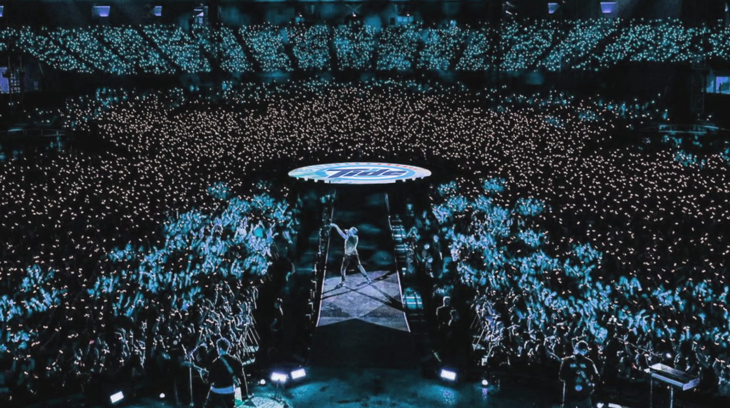 Concert moment where music, movement, and climate awareness unite under a glowing Tide dial.