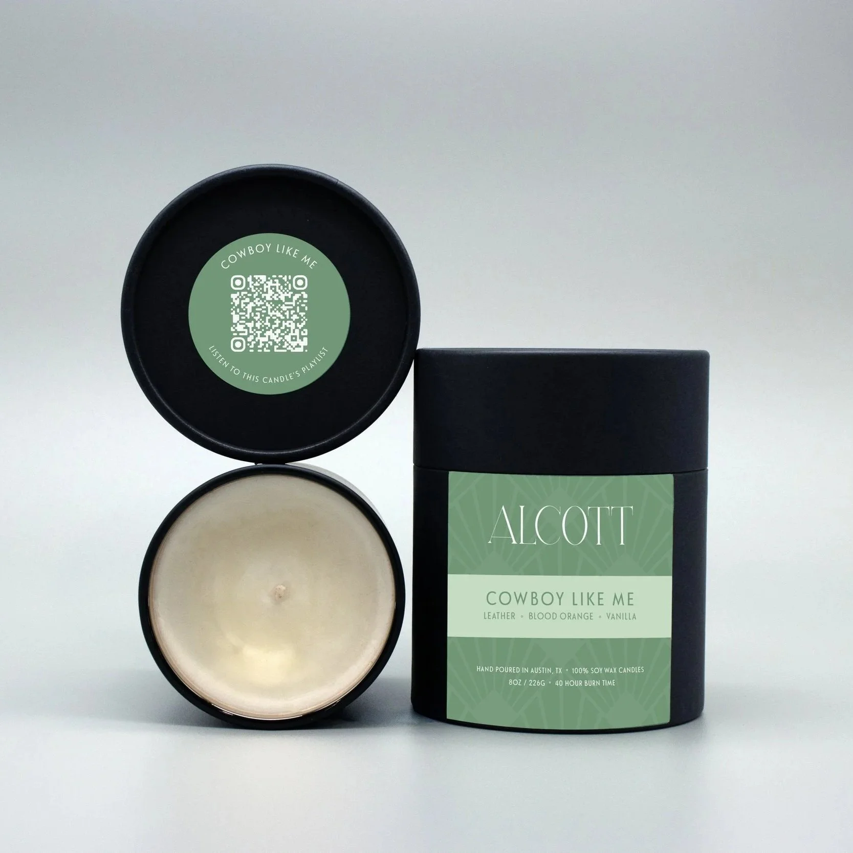 Clean burning candle Cowboy Like Me next to black and green plastic-free packaging.