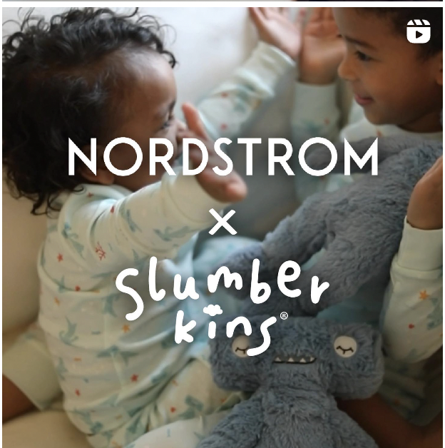 Two children in pajamas play with a gray plush toy. The overlay text reads "Nordstrom x Slumberkins."