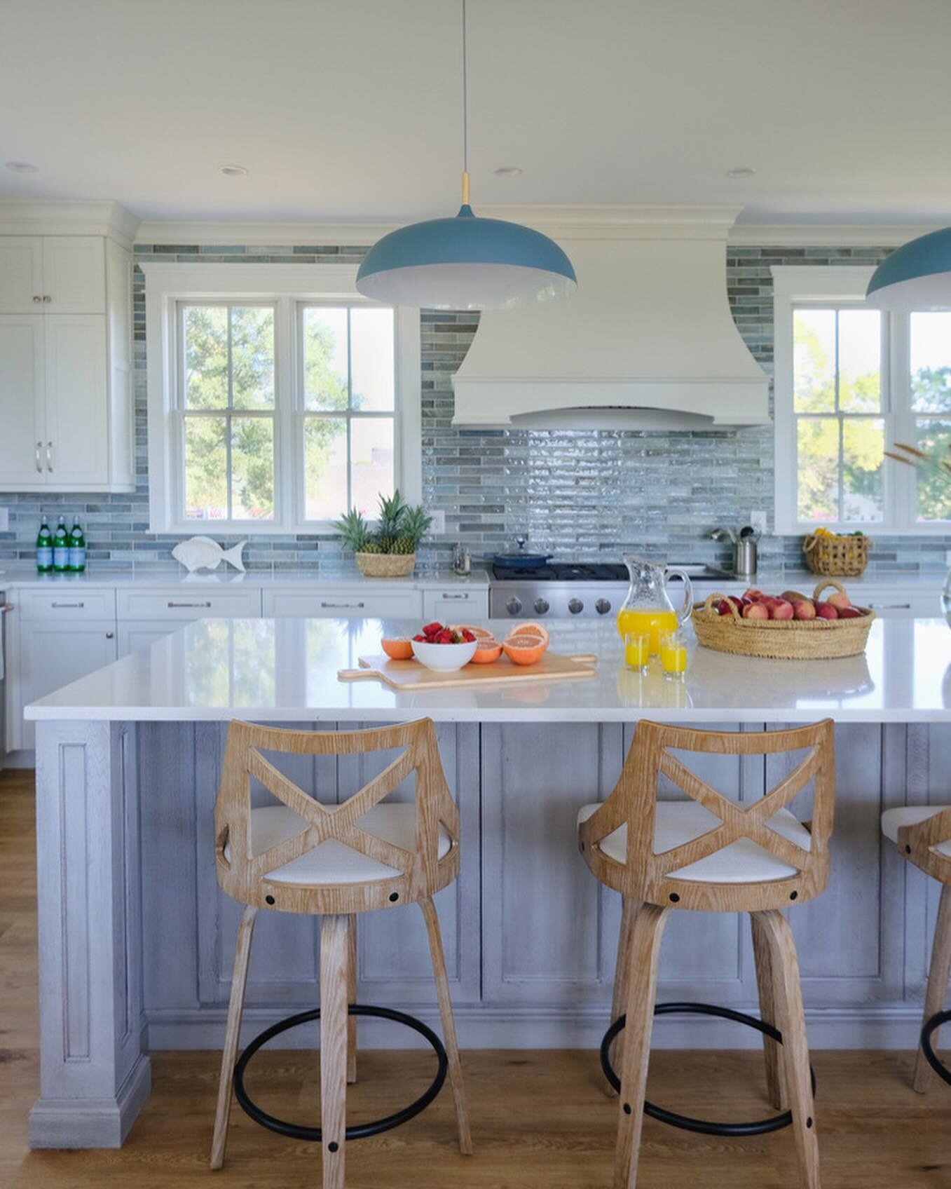 We selected a classic subway tile for this kitchen in shades of blue to give it a coastal feel. These zellige tile are handcrafted making each one is unique. The large wooden island ties it all together with plenty of seating and workspace. Photo cre