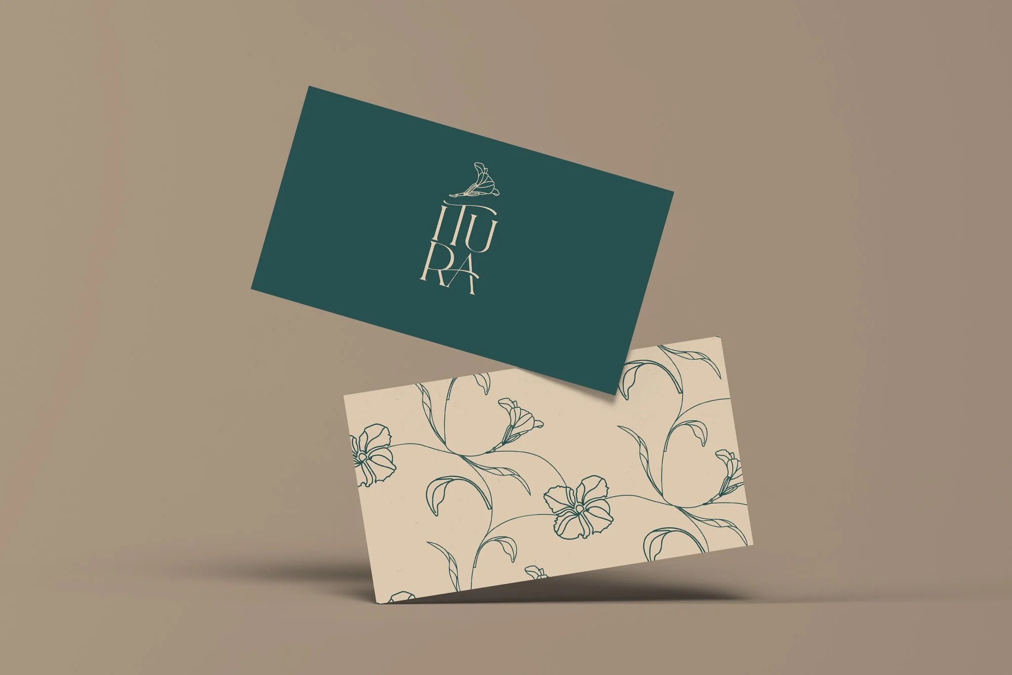 Two business cards, one dark teal with a logo of a ballet dancer and the words 'IU RA' and the other cream with a floral line drawing pattern, placed on a beige background.