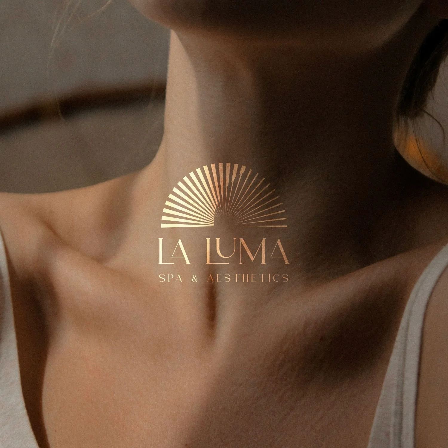 Close-up of a woman's bare neck and shoulder with a logo for La Luma Spa & Aesthetics overlayed