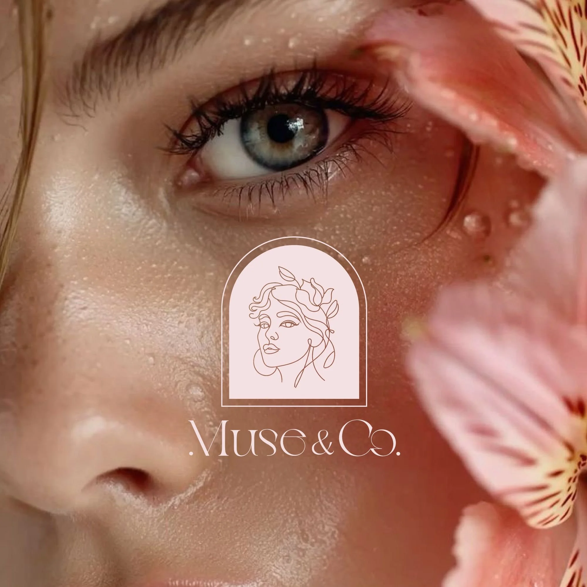 Close-up of a woman's face with a focus on her eye, surrounded by pink petals, with a logo of a line-drawn woman's face and the text '.Muse&Co.' overlayed.