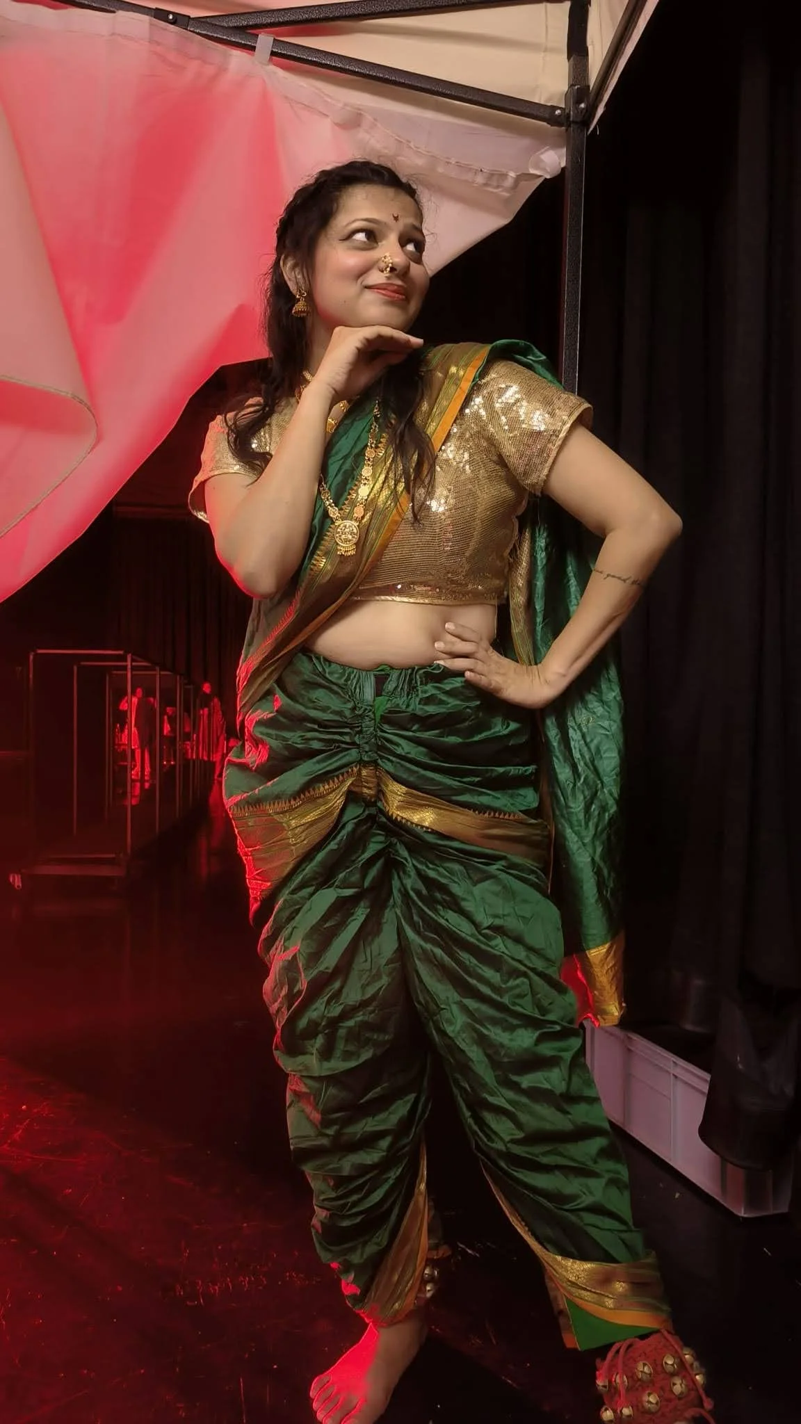 Woman in colorful traditional Indian attire dancing at a cultural festival.