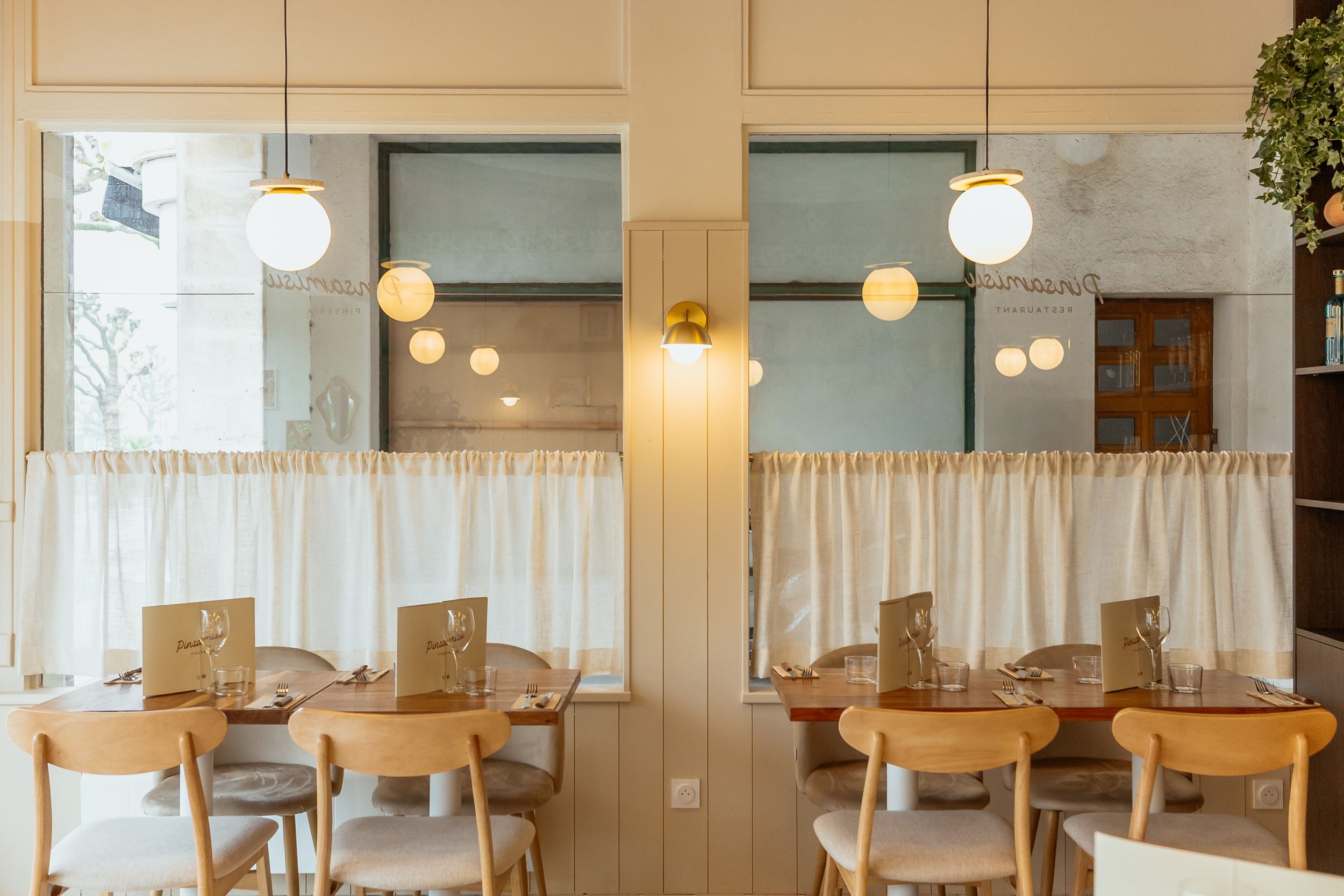 Salle interieur du restaurant donnant sur une petite ruelle, ajout de rideaux avec suspension et applique pour donner de la chaleur au lieux