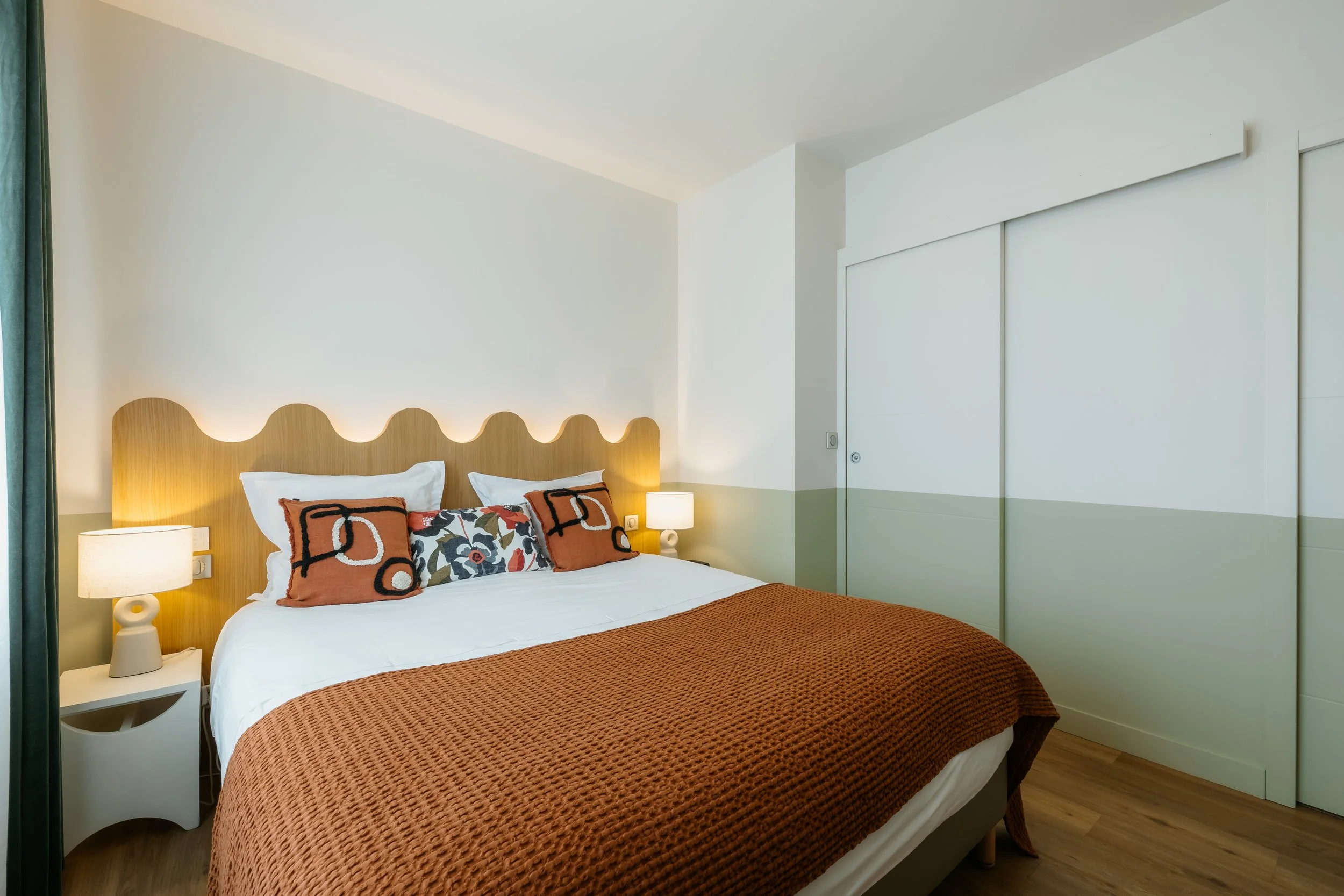 Chambre lumineuse moderne et confortable avce un mur  colorer de vert d'eau pour refléter la végétation extérieur
