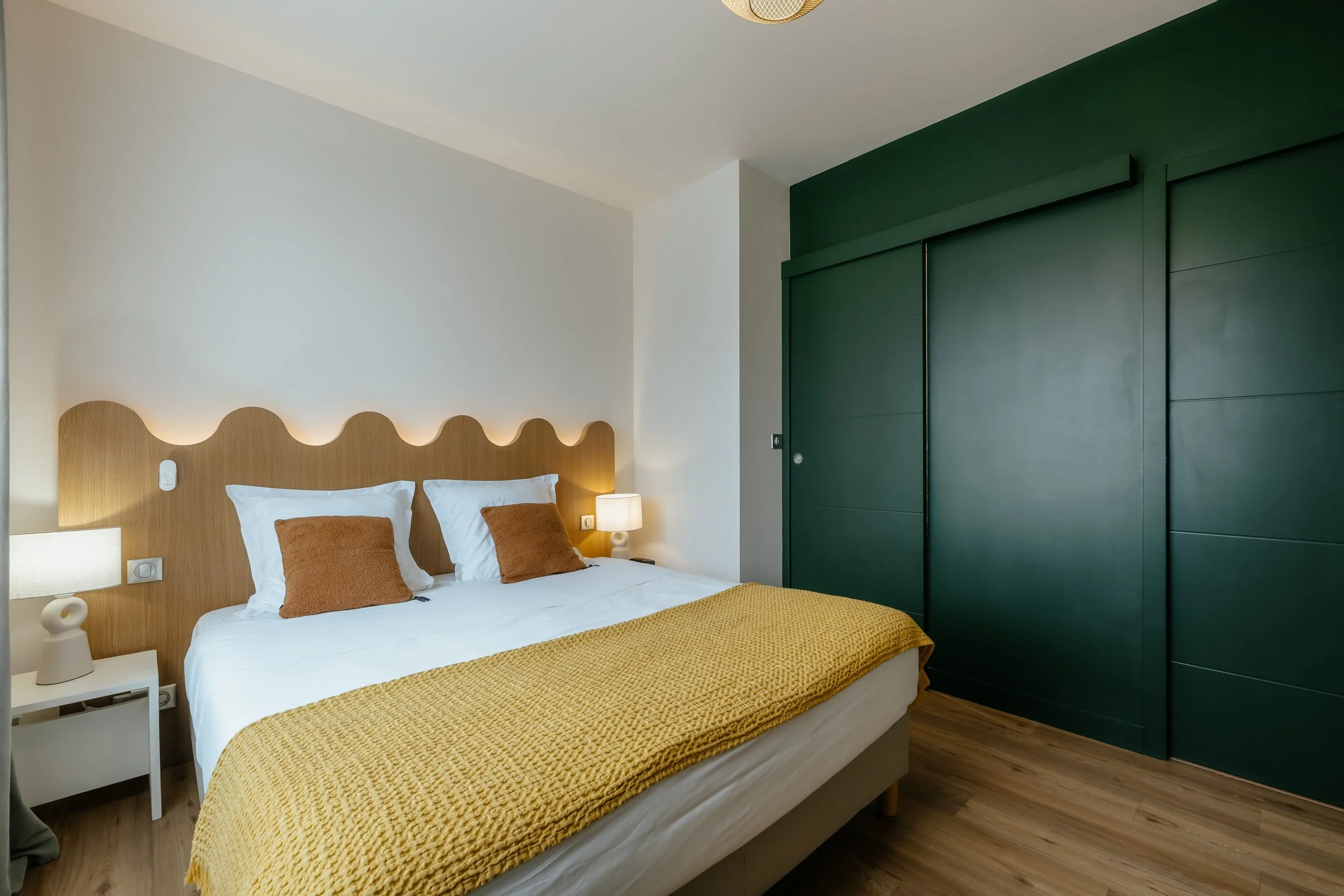 Chambre lumineuse moderne et confortable avce un mur  colorer de vert foret pour refléter la végétation extérieur