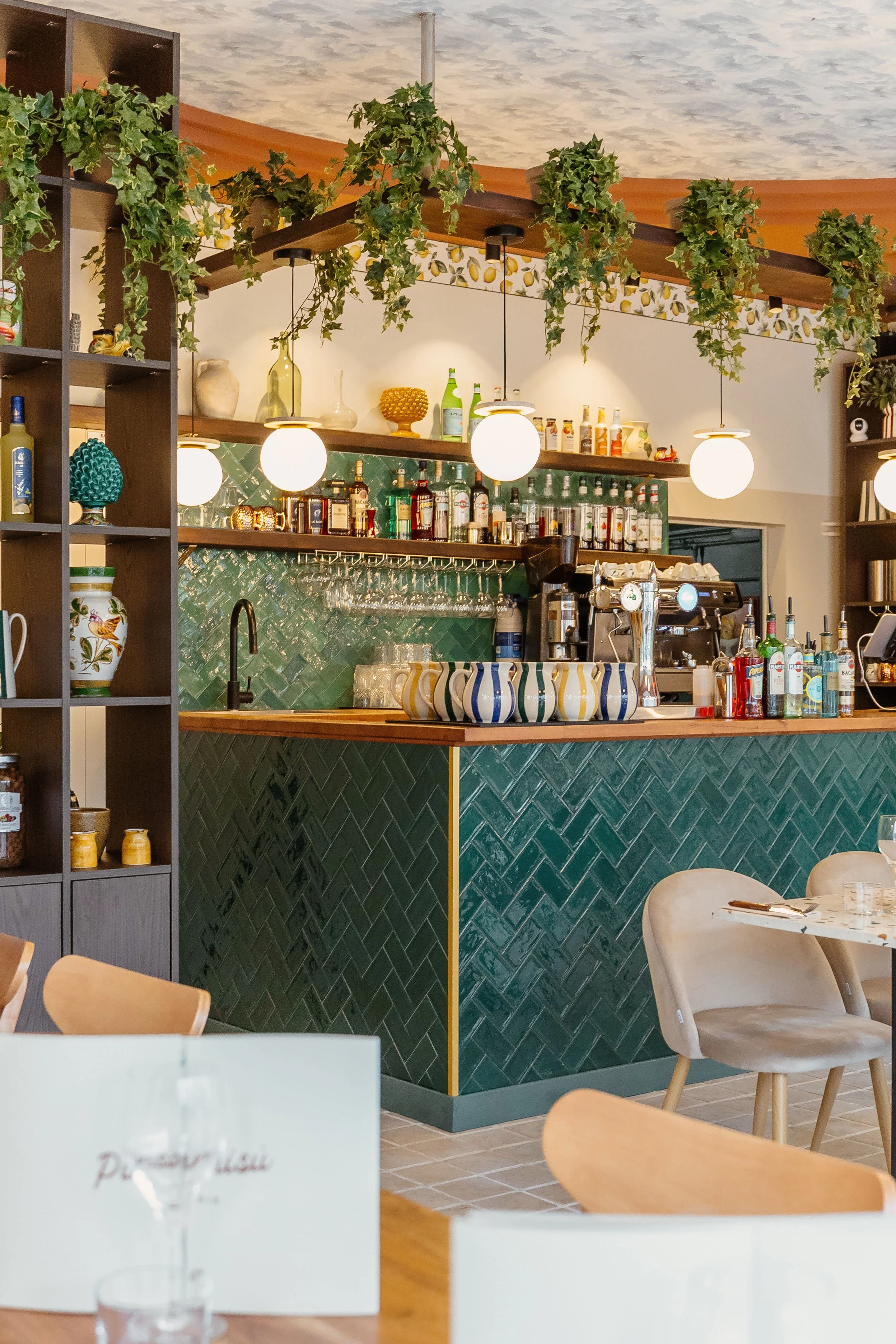 Bar du restaurant dans la salle élégant en carrelage vert émeraude, avec un ciel de bar