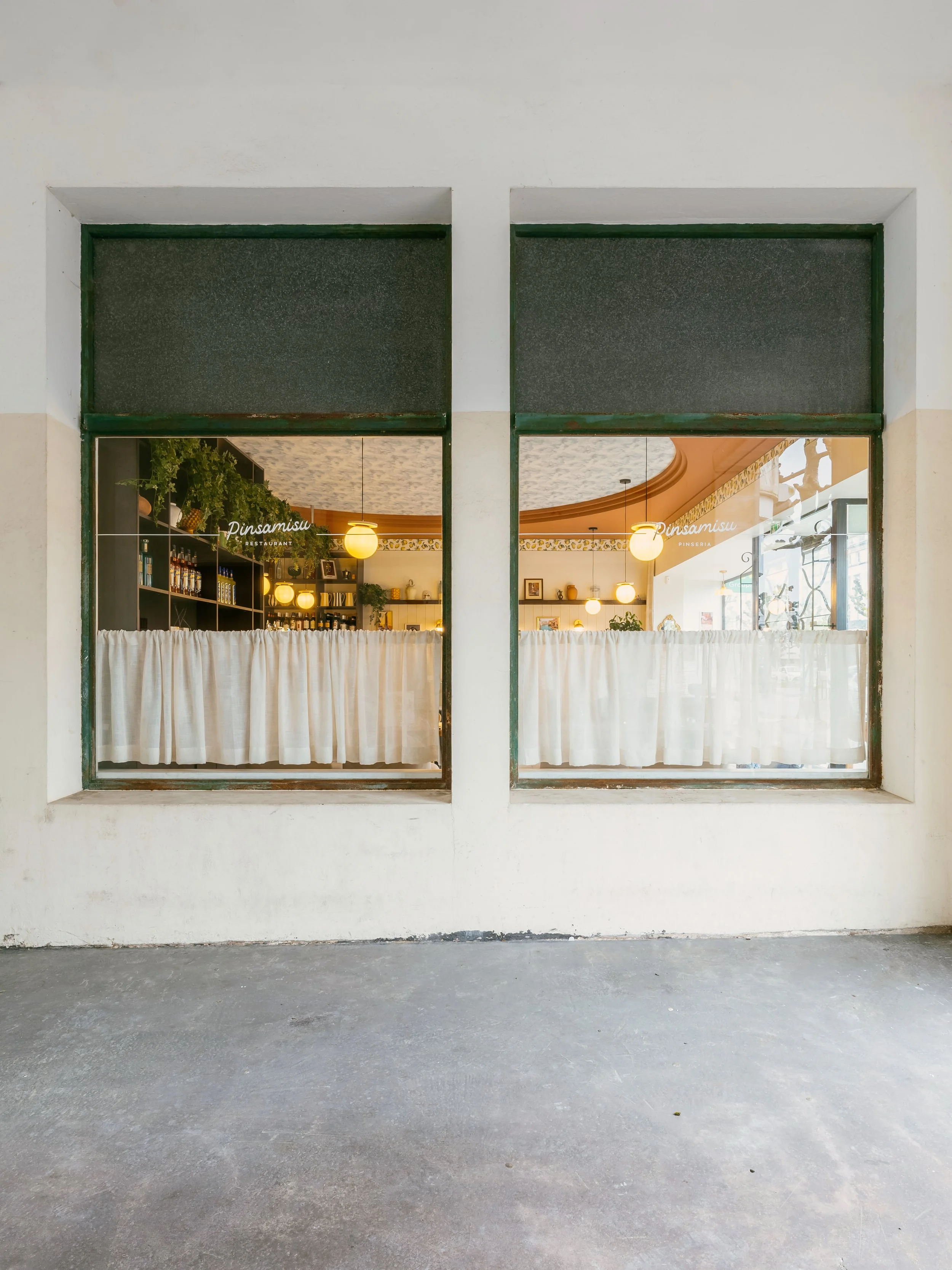vitrine  sur le coté dans la ruelle avec ces petits rideaux pour donner un aspect Romaine a ce lieux