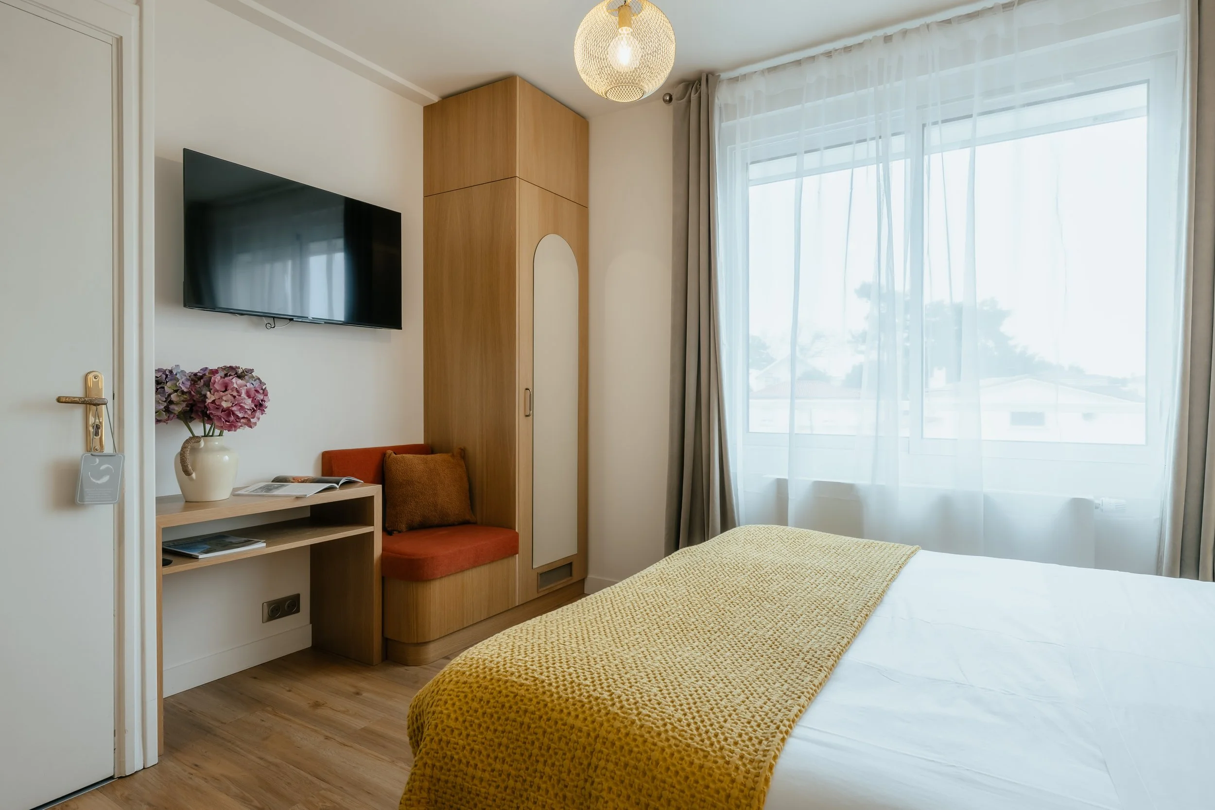 Chambre d’hôtel moderne avec lit double confortable, décoration design et ambiance chaleureuse pour un séjour reposant et confortable.