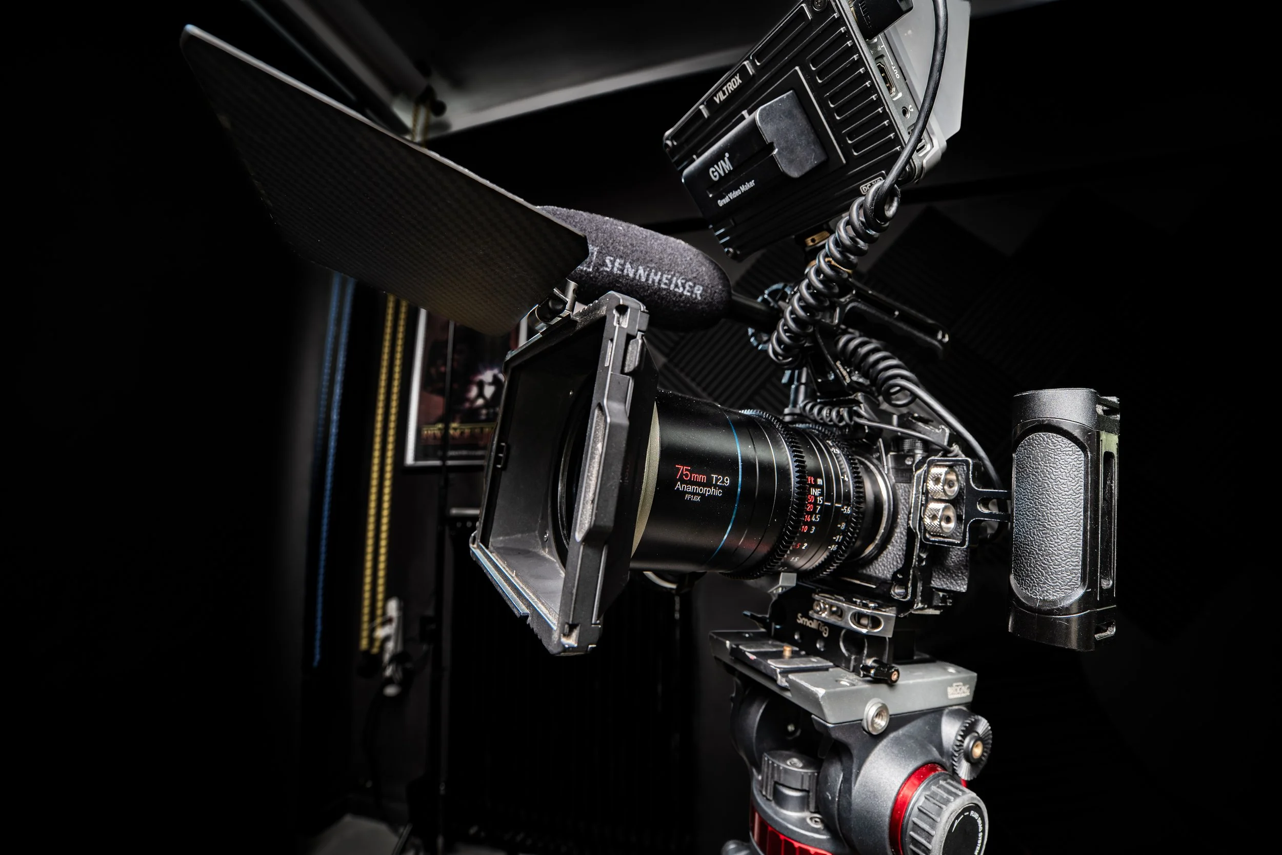 Close-up of a professional camera mounted on a tripod or stabilizer with electronic equipment attached, used for filming or photography.