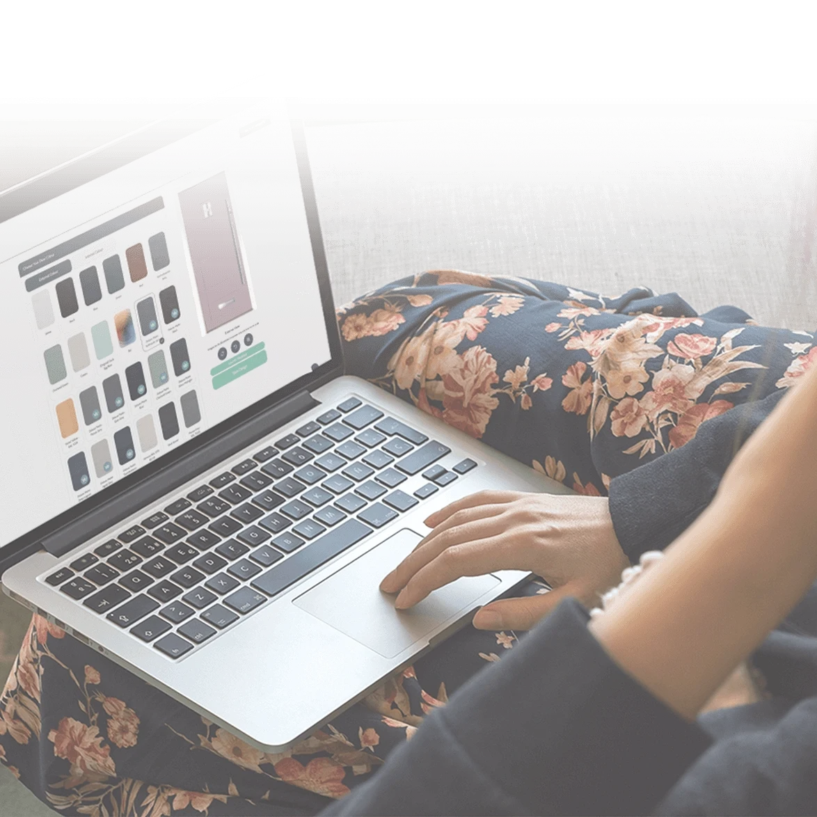 Person using a laptop with a floral skirt, browsing a design or product selection on the screen.