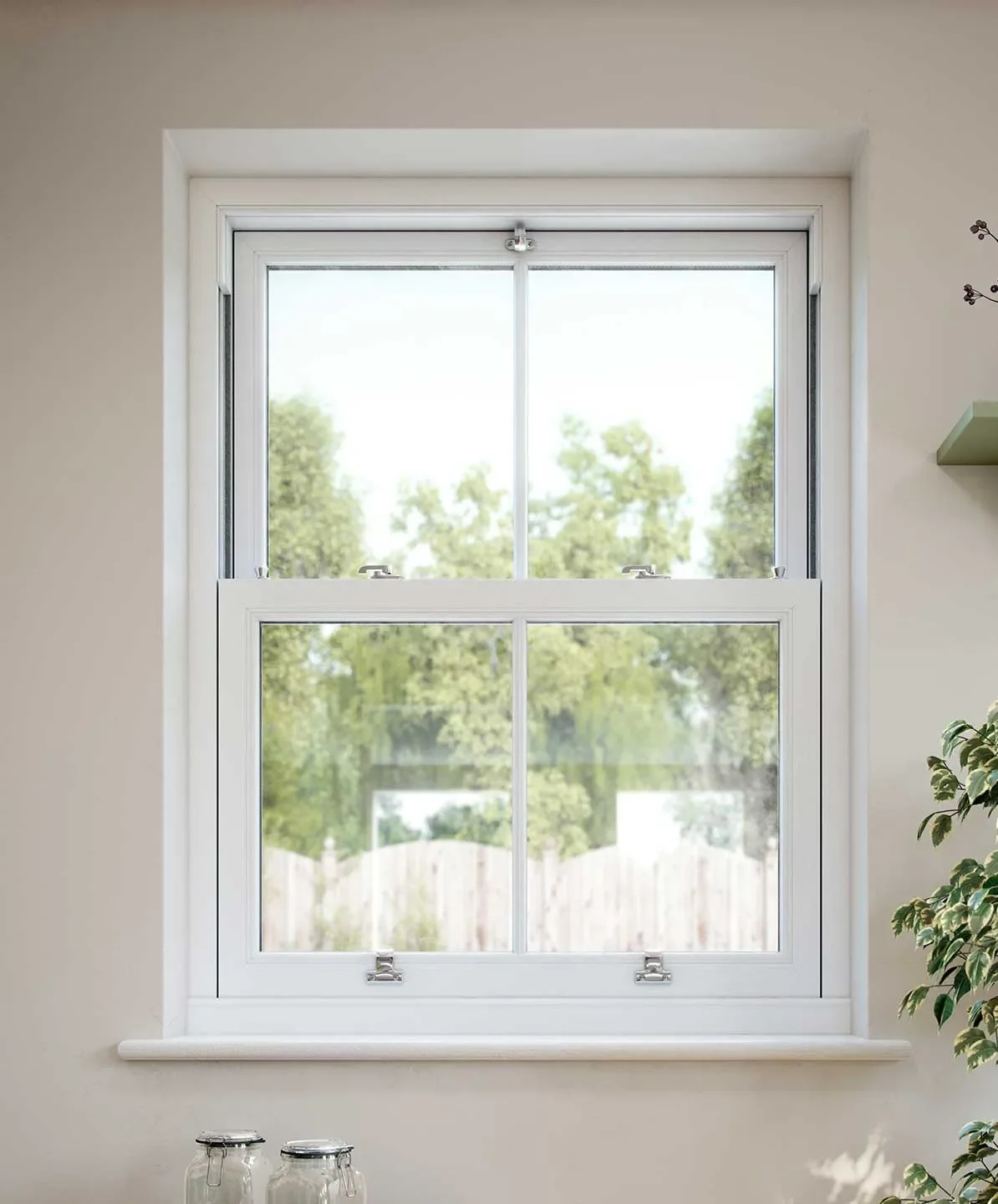 A white-framed double-hung window with two panes in each sash, showing trees and a wooden fence outside, with a beige wall inside.
