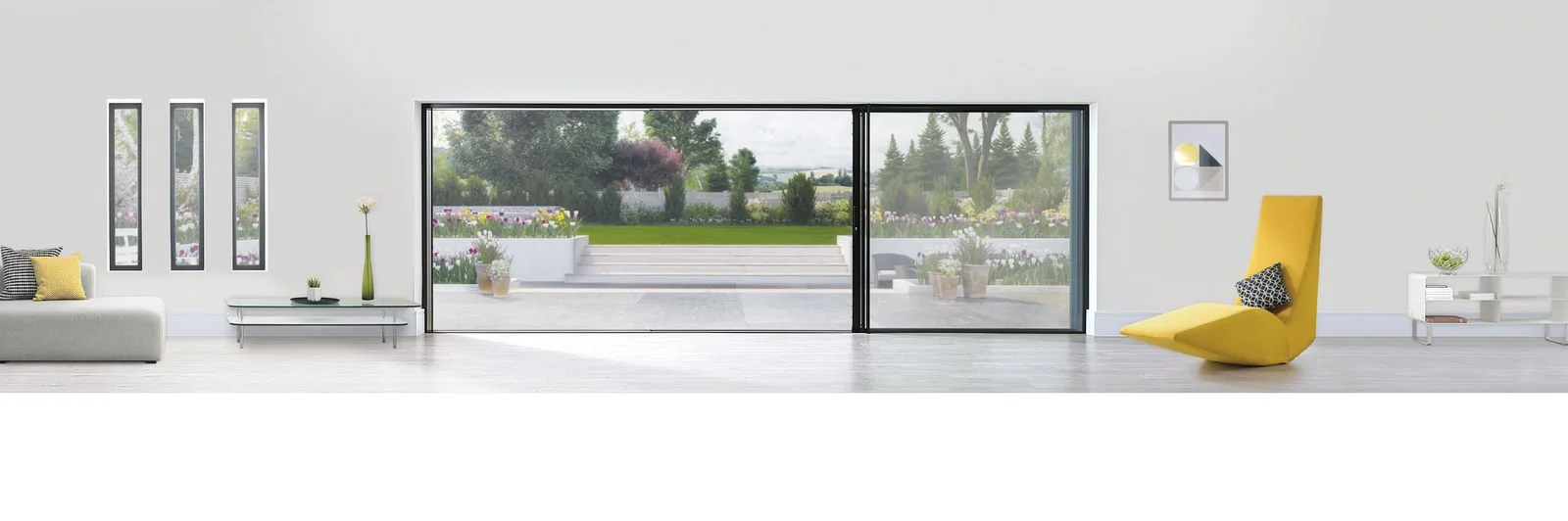 Modern living room with white walls and light wood flooring, featuring a yellow lounge chair, a white sofa with cushions, sleek minimalistic white and black furniture, and large sliding glass doors opening to an outdoor patio with greenery and flower