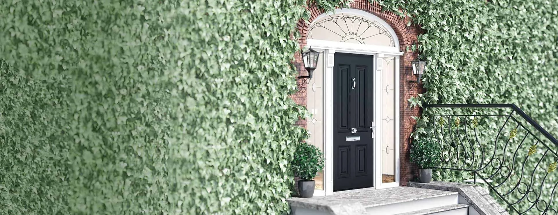 Black front door with white trim on brick house, surrounded by green ivy, with black wall-mounted lanterns and potted plants near the entrance, and a decorative metal handrail on the stairs.