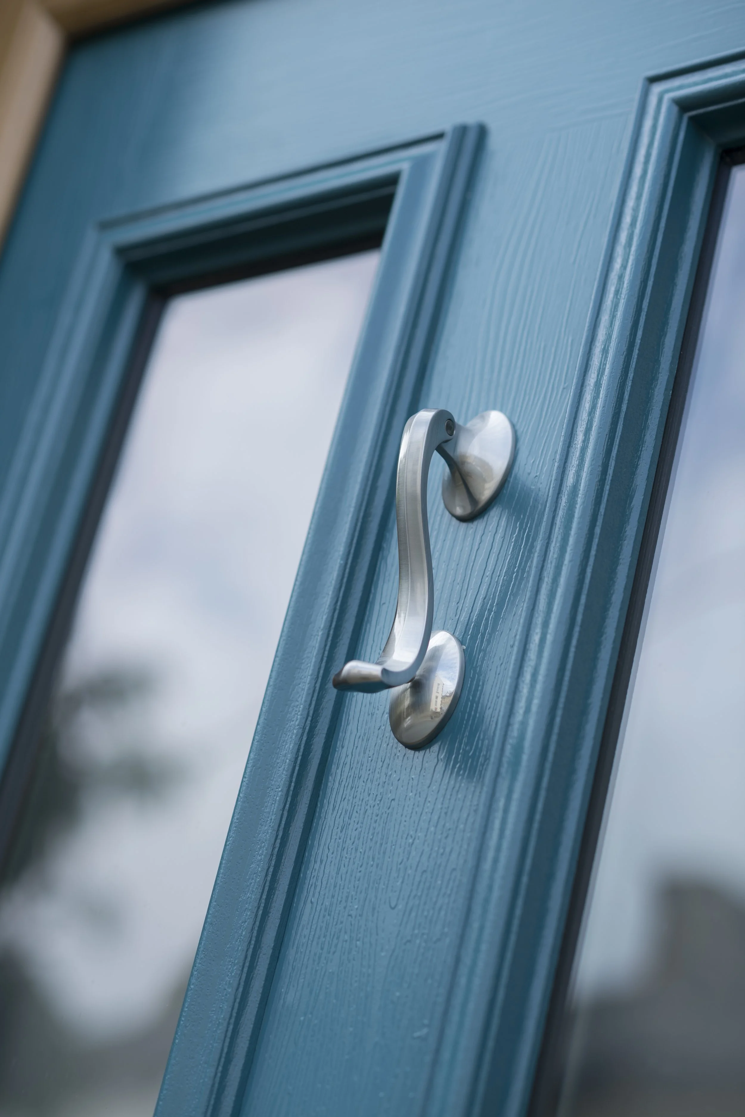Close-up of a blue door with a silver door handle.