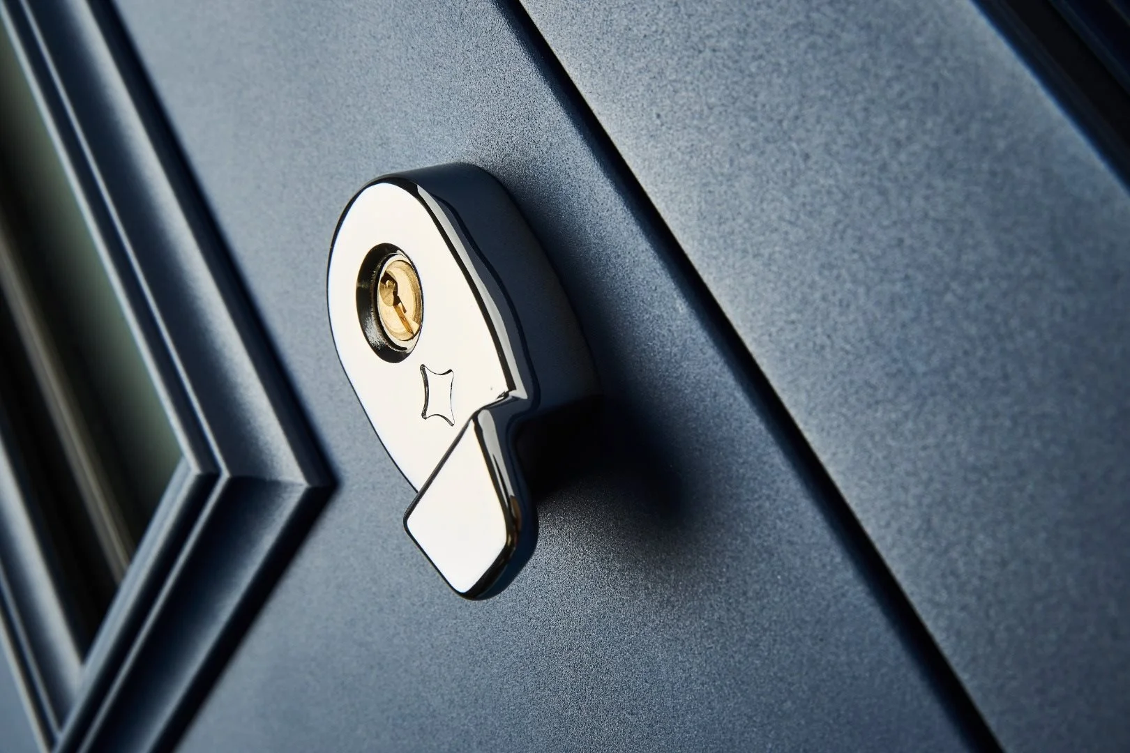Close-up of a computer lock with a keyhole on a dark gray textured surface.