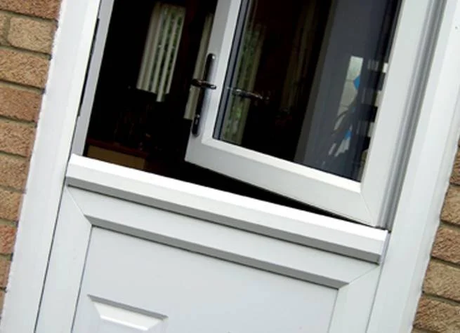 Close-up of a white stable door, installed on a brick wall, showing an indoor space through the open door.