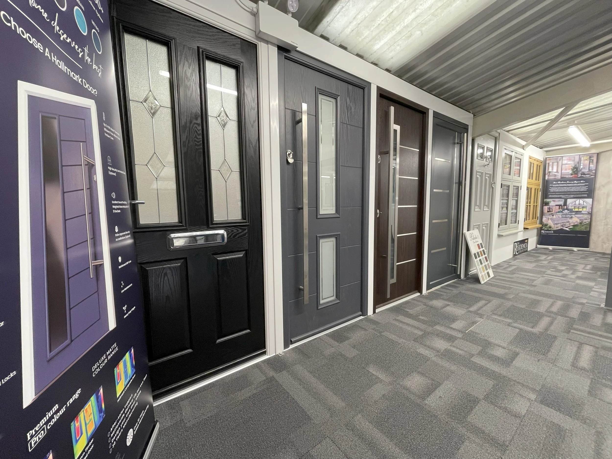 Display of various exterior doors in a showroom with a carpeted floor.