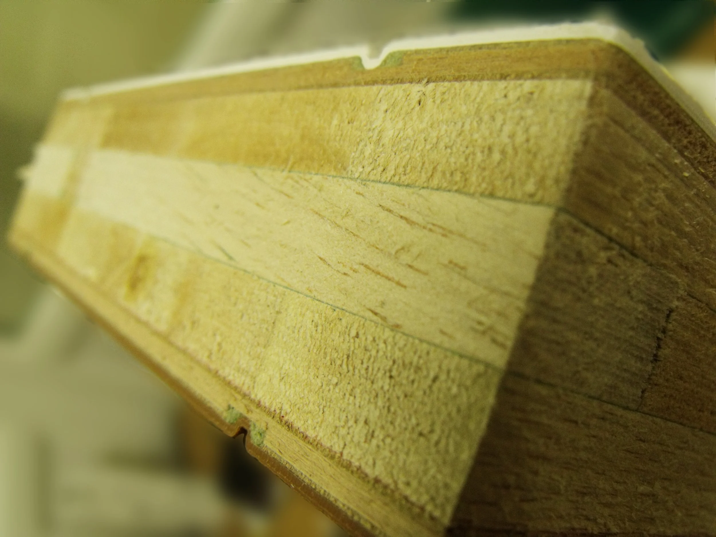 Close-up of a wooden bookshelf or wall unit with visible wood grain and a notch or cutout on the edge.