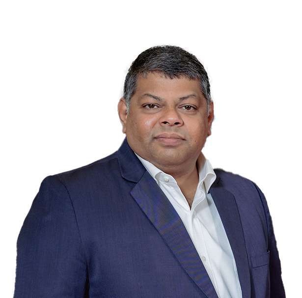 Professional man in a navy blue suit and white shirt posing for a photo against a plain background.
